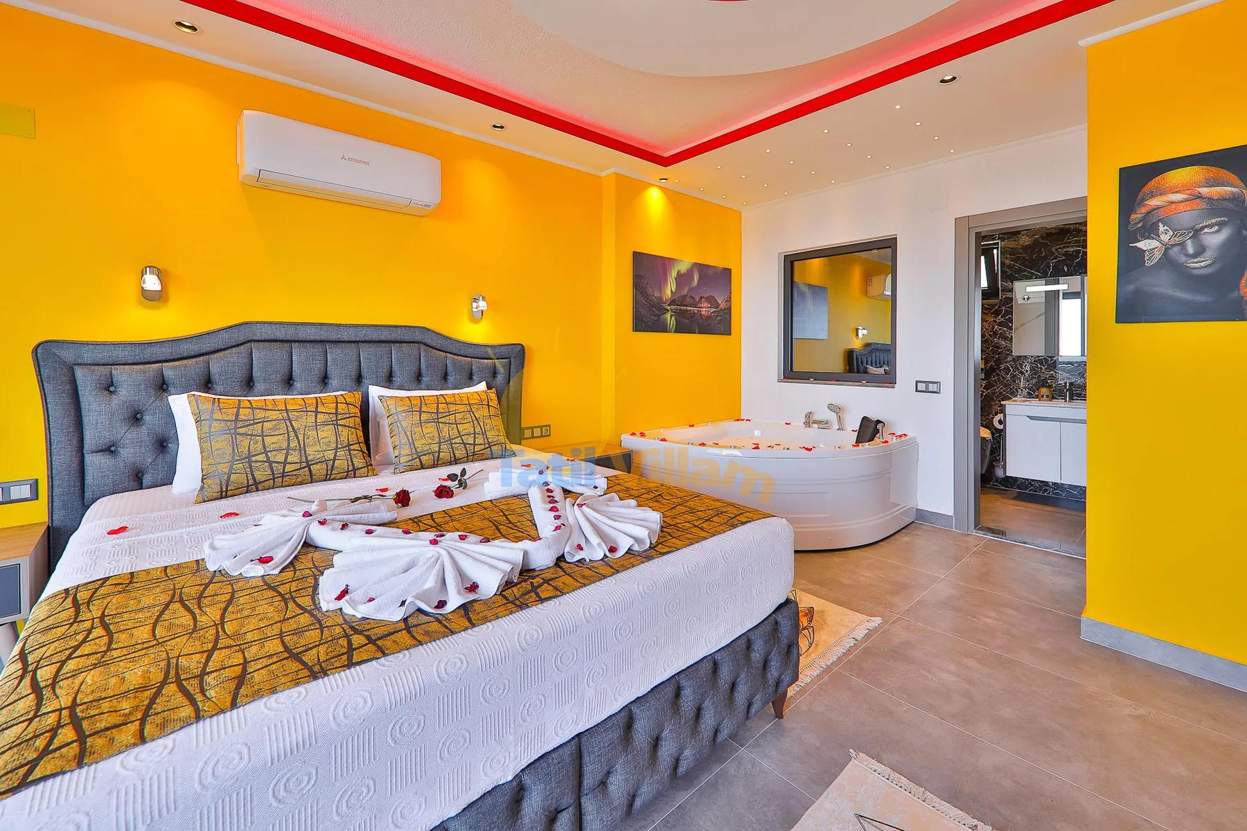 A bedroom with a large bed and a bathtub beside the sleeping area.