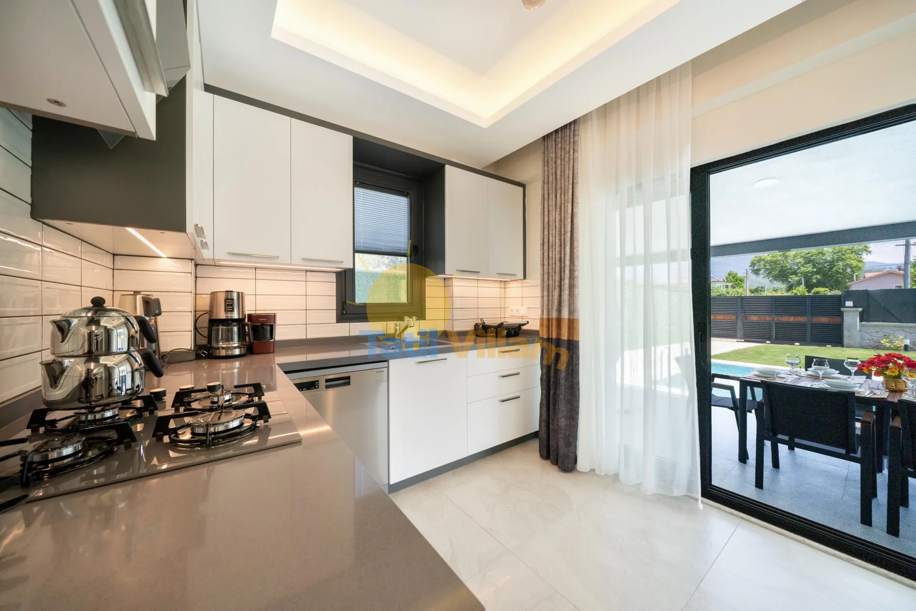 Una cocina moderna da a un patio a través de grandes puertas de vidrio.