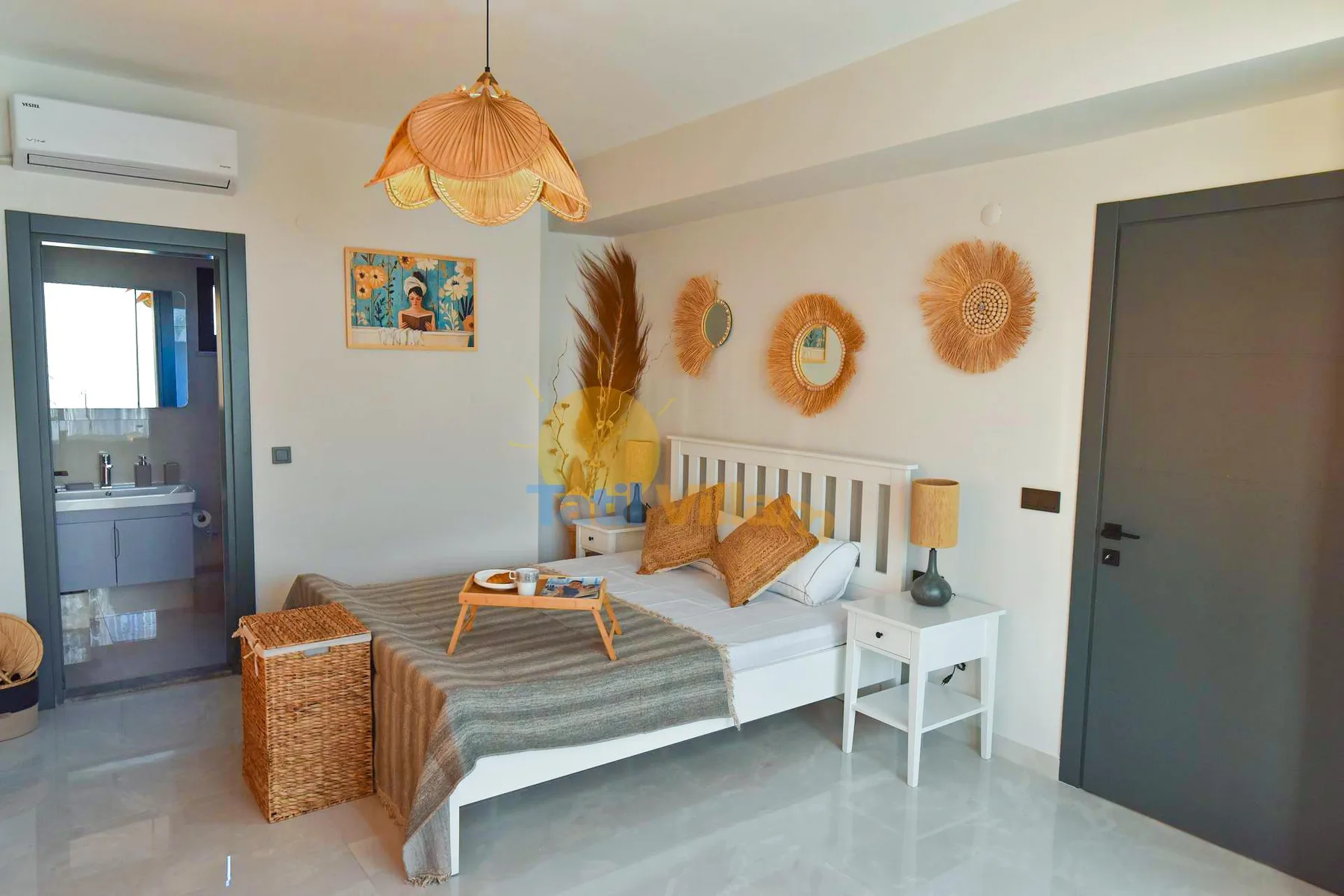 A bedroom with a white bed, striped bedding, woven wall decorations, and a small bedside table.