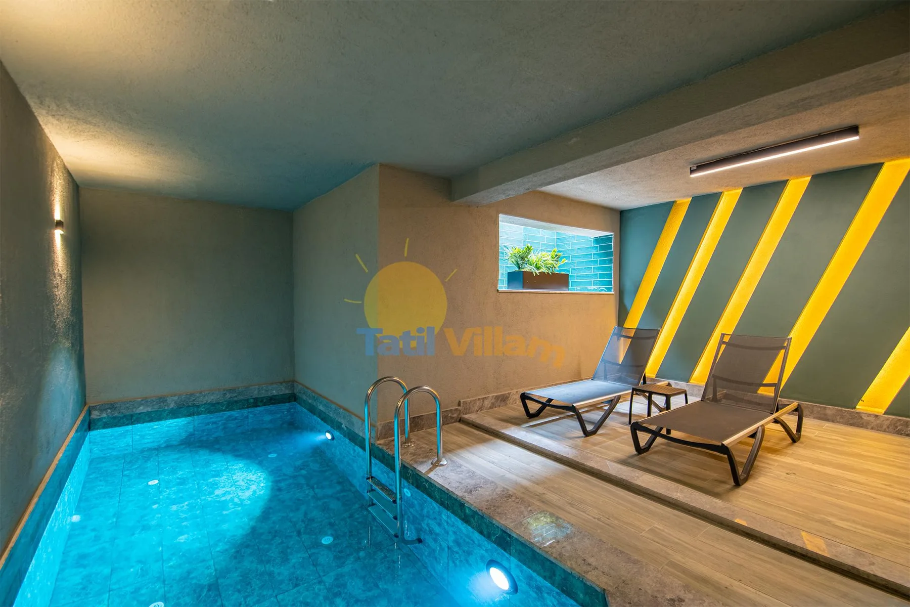 An indoor pool sits beside a wooden deck with lounge chairs and bright yellow diagonal wall accents.