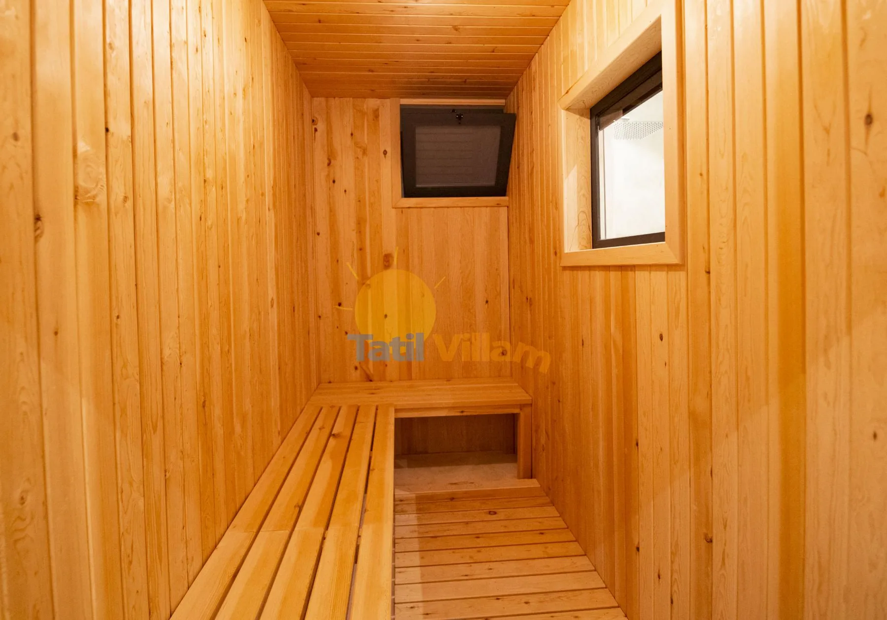 A wood-paneled sauna room with a long bench and small windows.