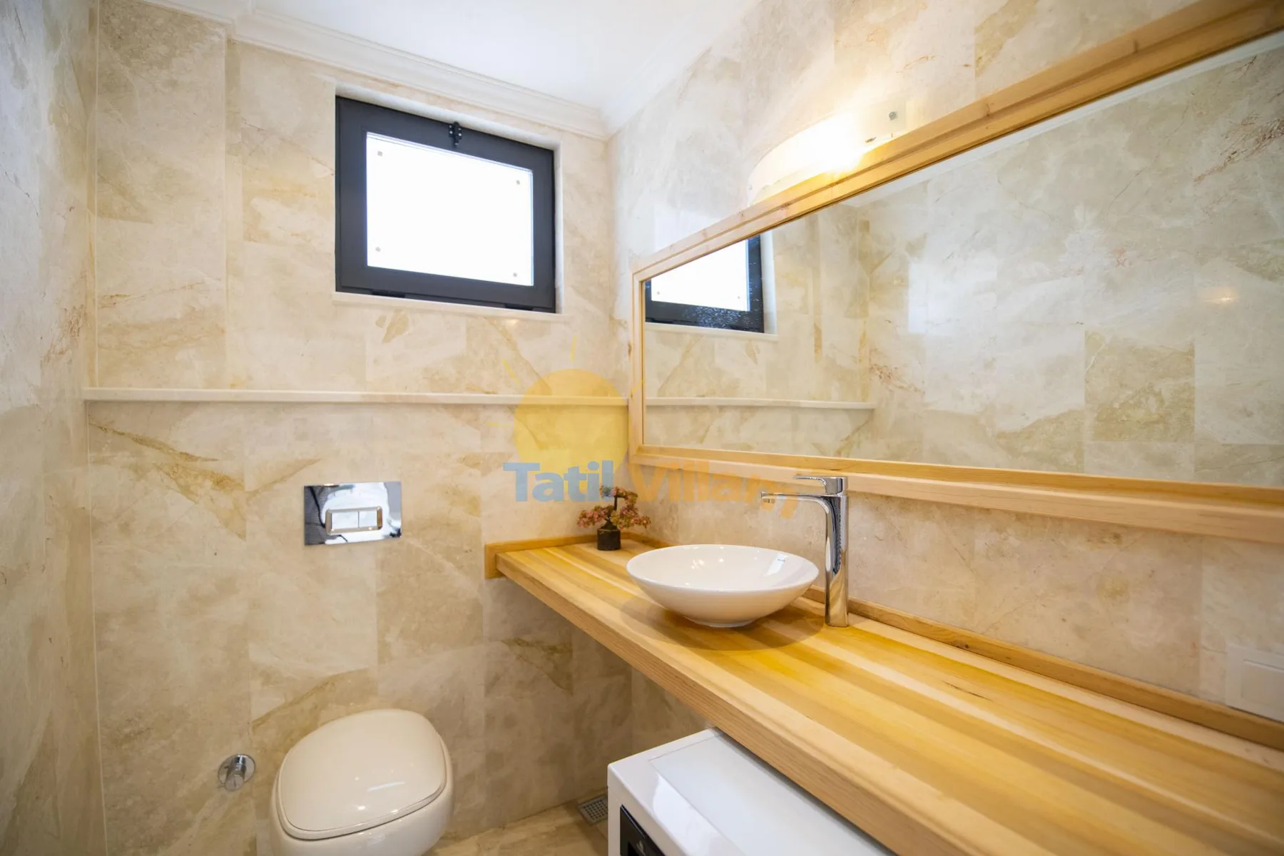 A tiled bathroom with a sink, mirror, and toilet.