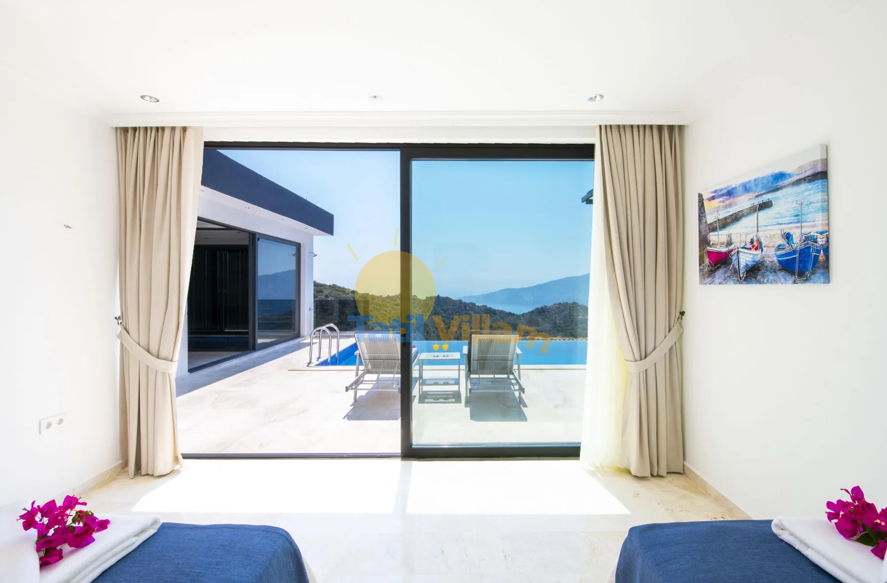 A bright bedroom opens onto a terrace with a pool and distant hills.