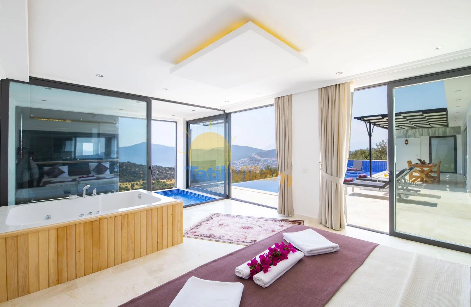 A bright room with a built-in bathtub, large windows, and a view of the hills.