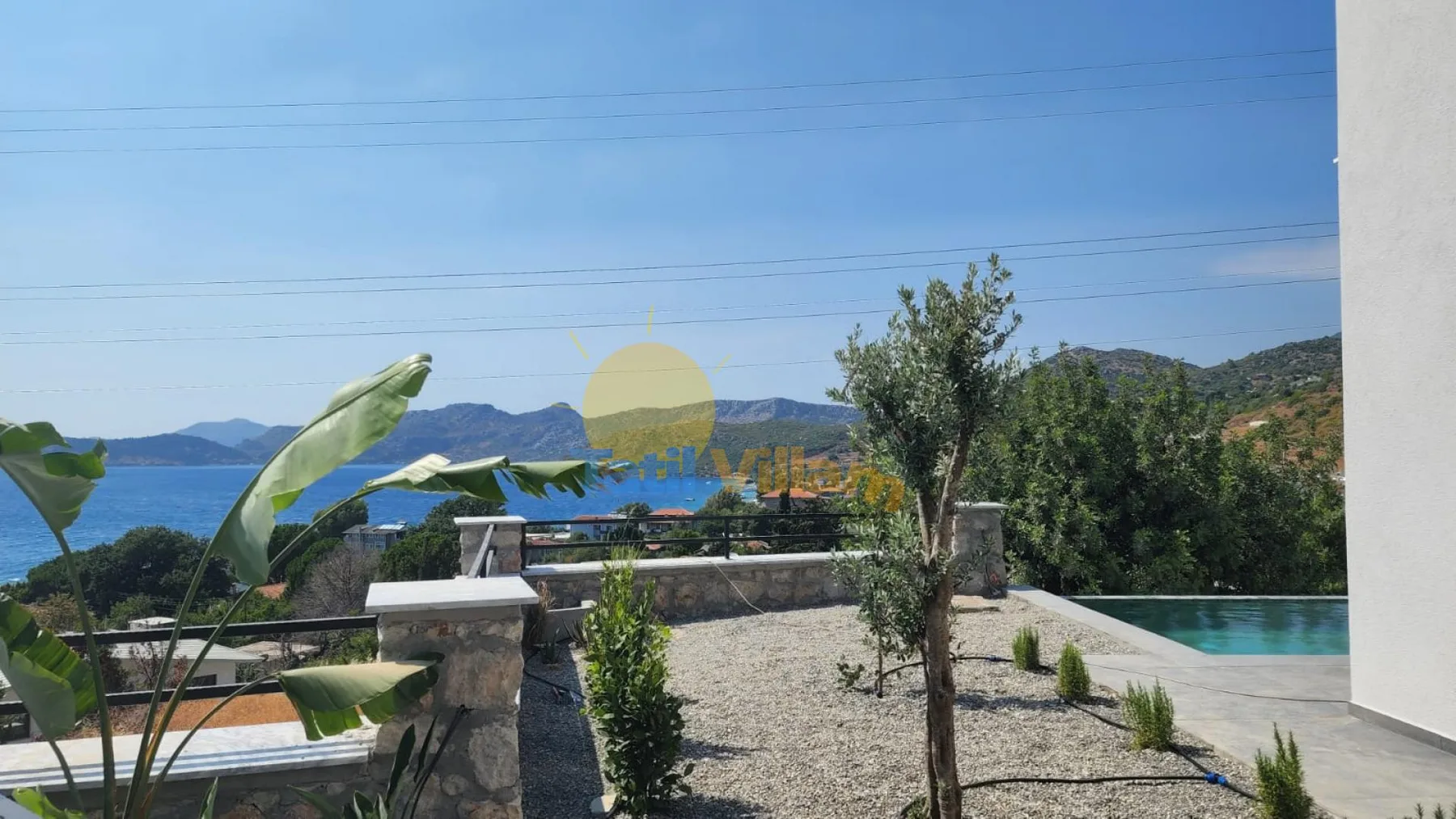 Una terraza en la azotea da a una piscina, un lago y colinas lejanas.