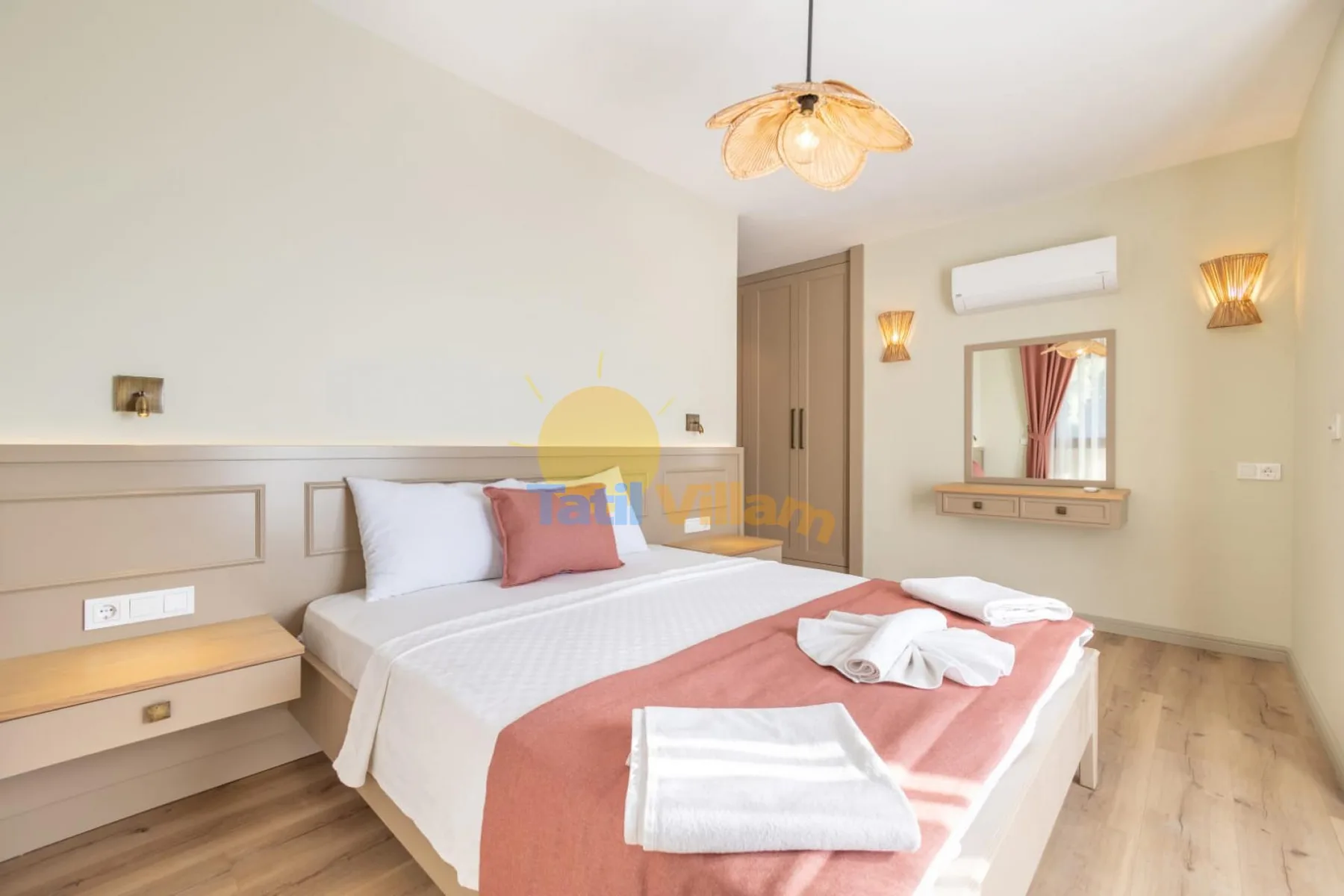 Un dormitorio con una cama doble, ropa de cama blanca y una colcha color coral.