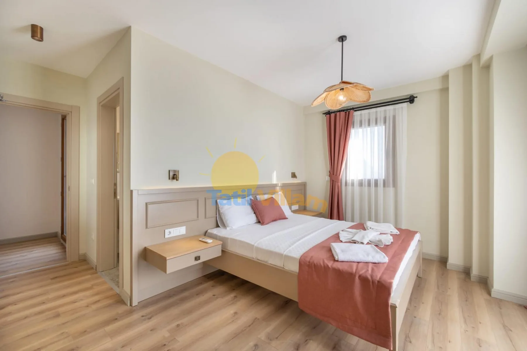 Dormitorio con cama, mesa de noche y ventana con cortinas.