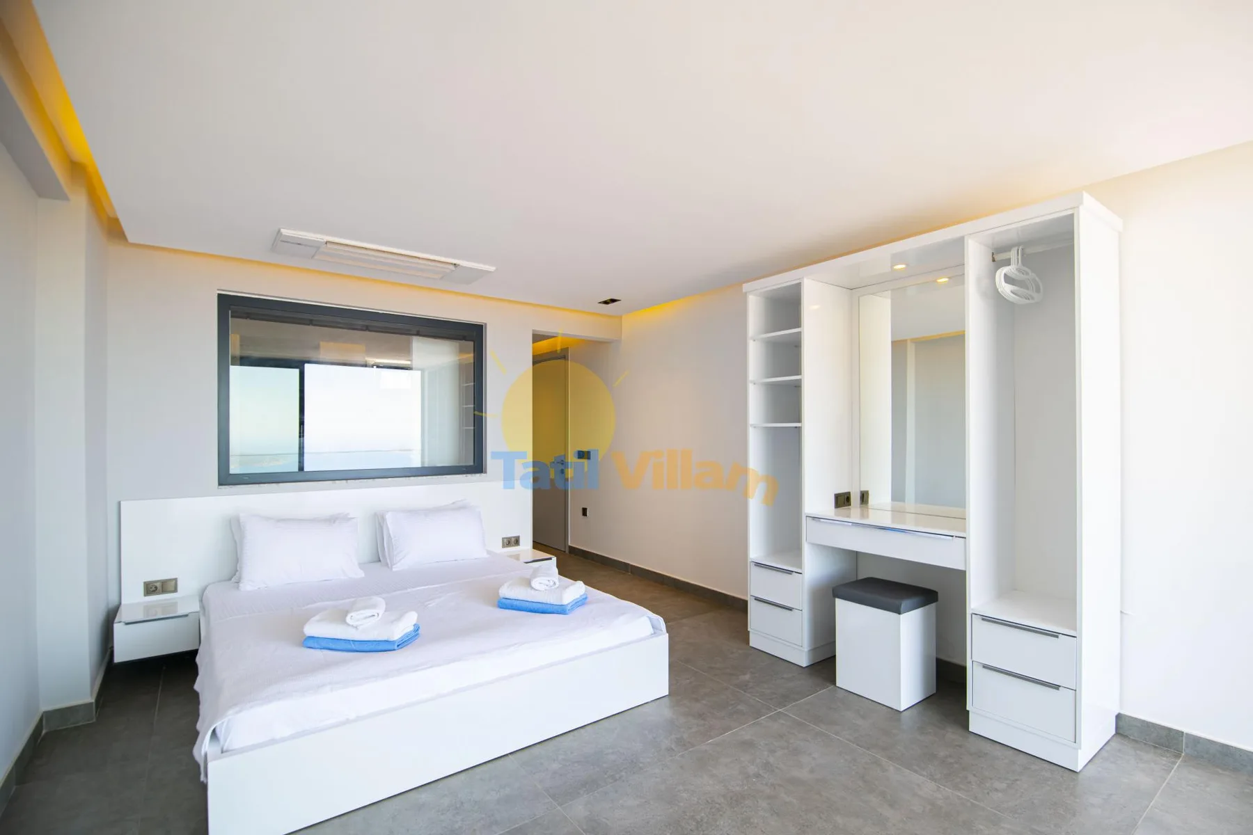 A bright bedroom with a neatly made bed and a built-in wardrobe.