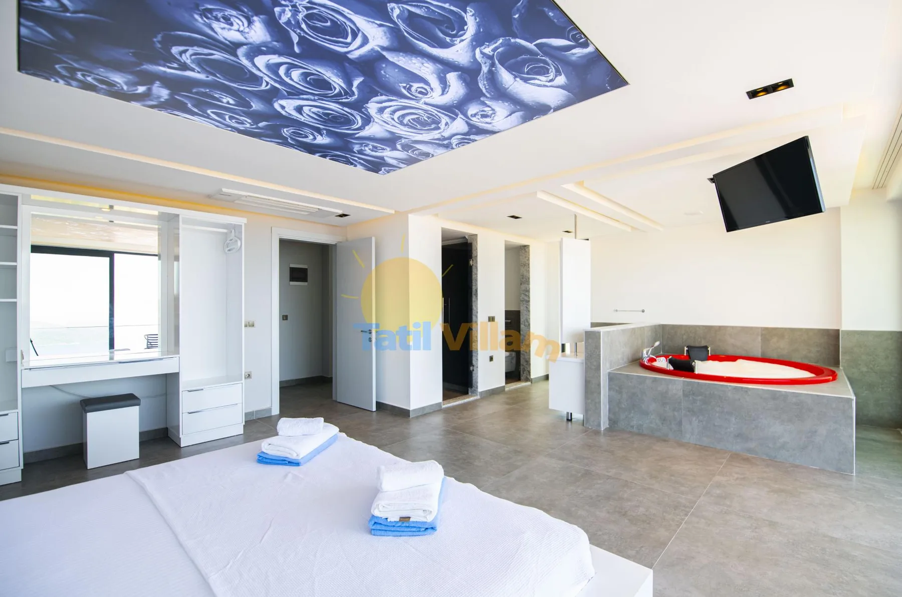 A bright bedroom opens onto a bathroom with a built-in bathtub.