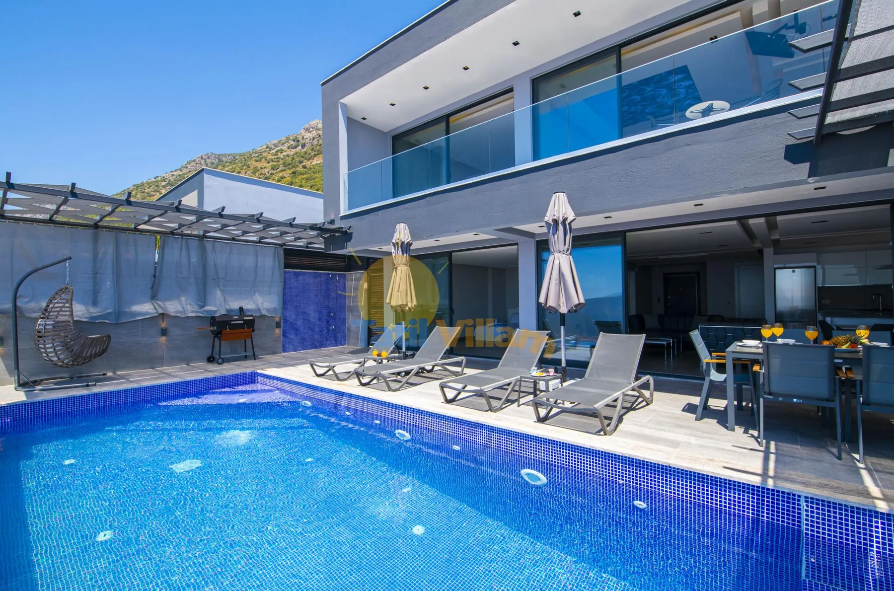 A modern house patio with a swimming pool, lounge seating, and an outdoor dining area.