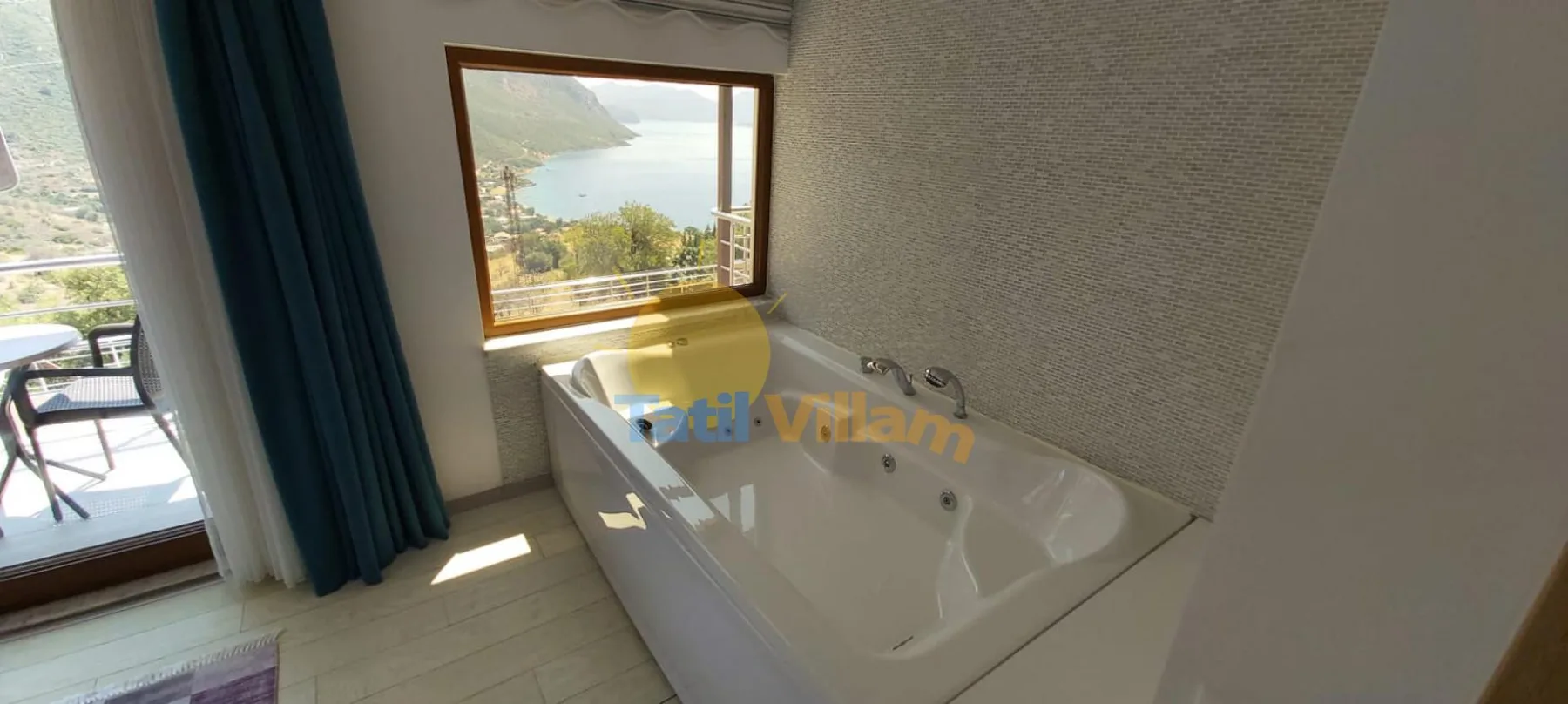A bathroom with a bathtub beside a window overlooking the landscape.