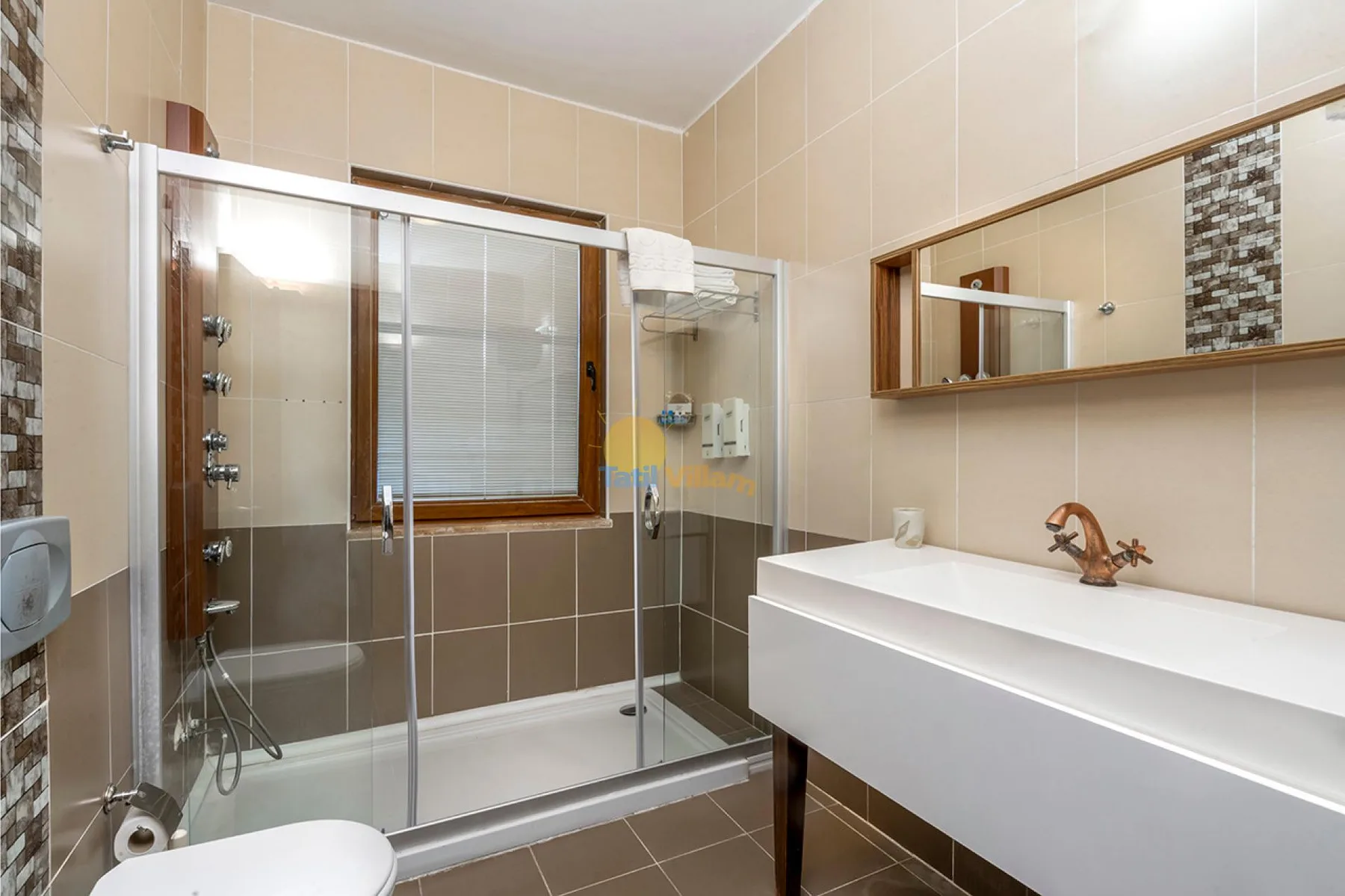 Un baño alicatado con ducha de vidrio, lavabo y espejo de pared.