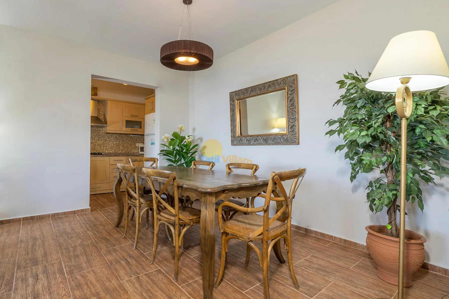 Un comedor con una mesa de madera y sillas junto a una cocina abierta.