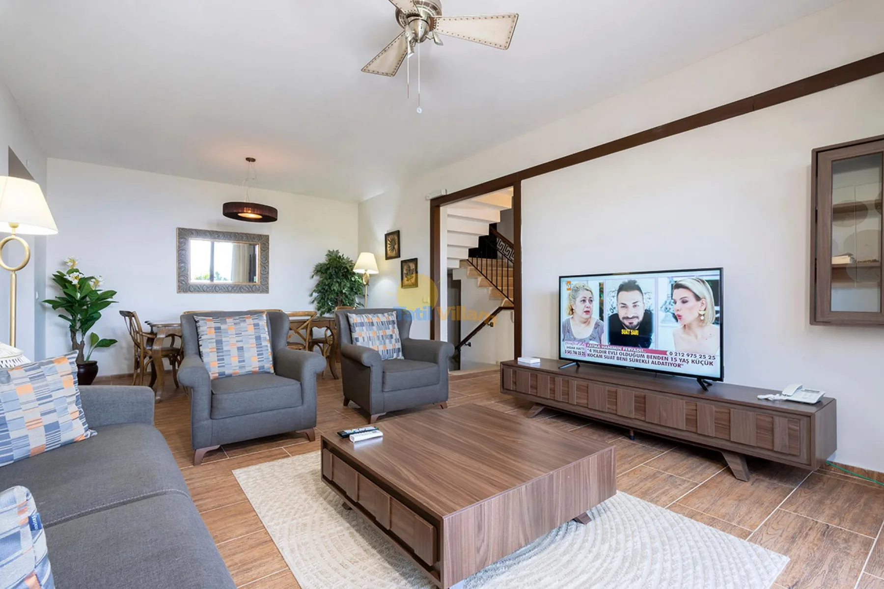 Una sala de estar con asientos alrededor de una mesa de centro y un televisor.