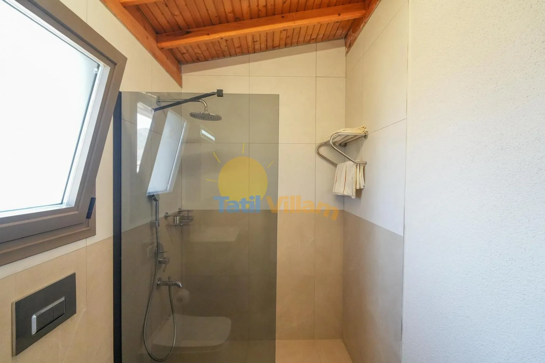 Un baño con ducha de vidrio, ventana y techo de madera.