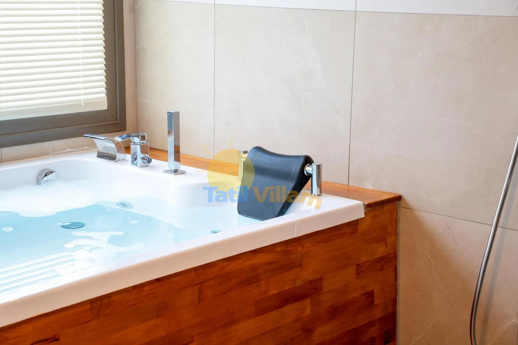 Un baño con bañera empotrada, paredes revestidas y una ventana con persianas.