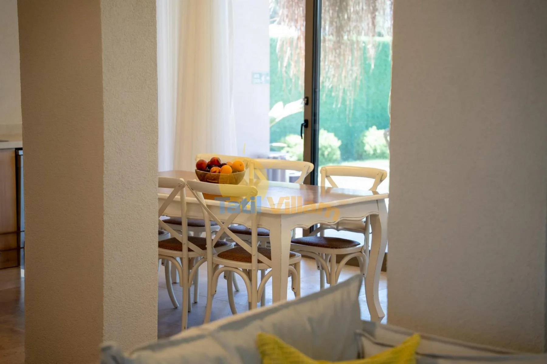 Comedor con una mesa y asientos junto a una puerta acristalada.