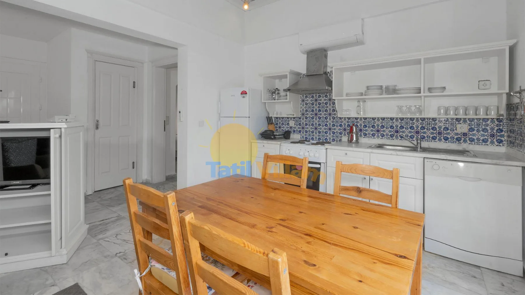 Una cocina y comedor con una mesa de madera y un salpicadero azul estampado.