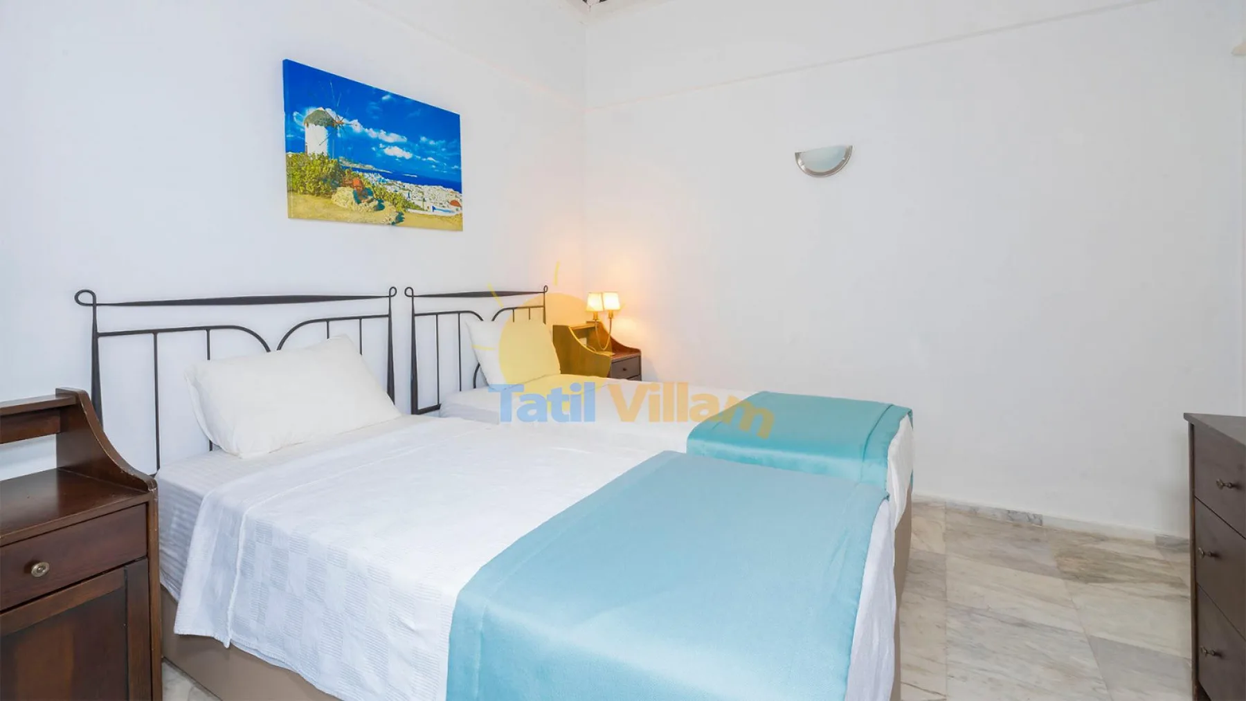 Un dormitorio con una cama vestida con ropa de cama blanca y turquesa.