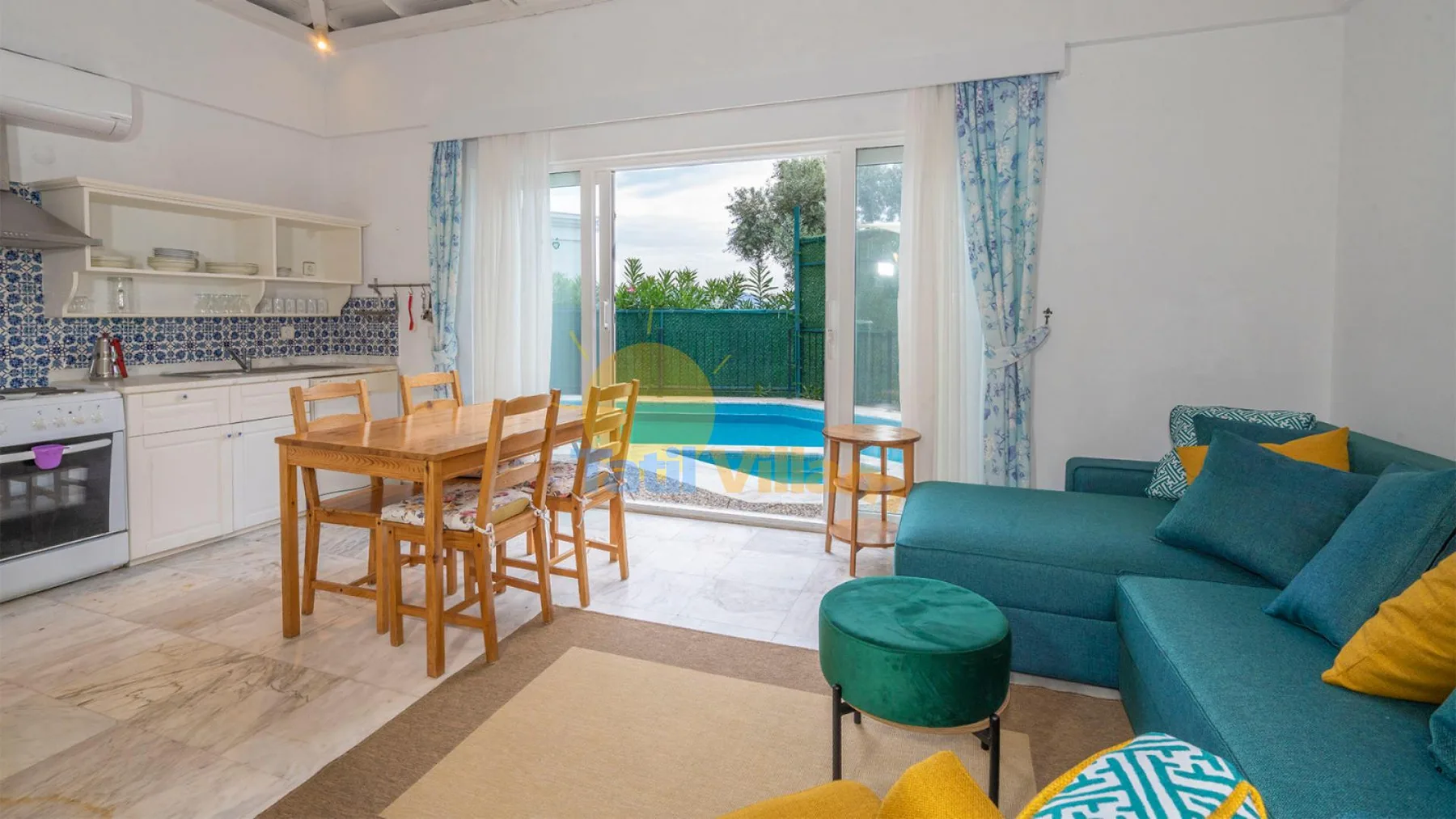 Una luminosa cocina abierta al salón, con una mesa de comedor junto a las puertas del patio.
