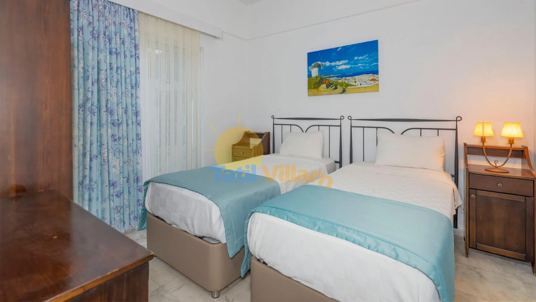 Un dormitorio con dos camas vestidas con ropa de cama blanca y turquesa.
