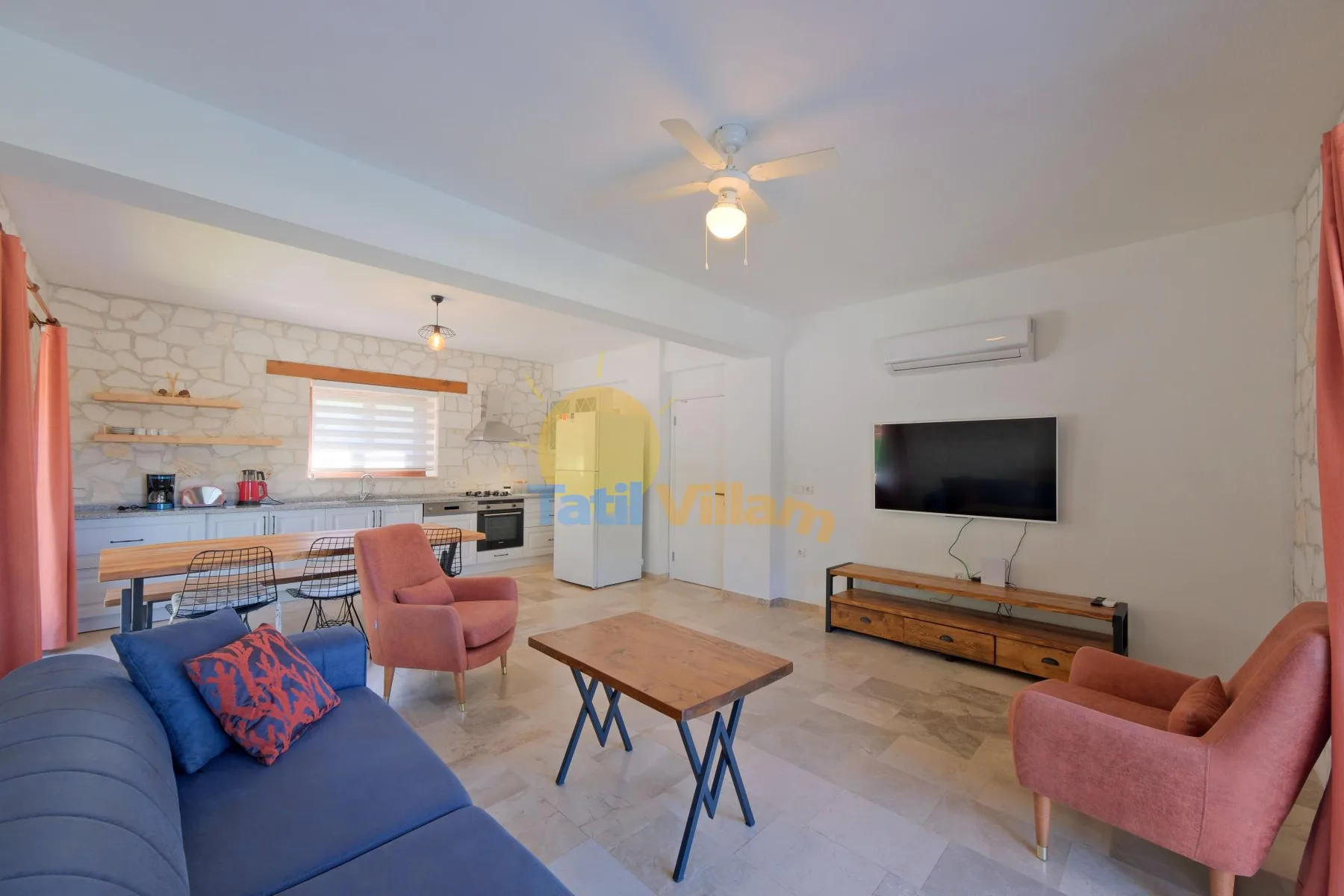 Una sala de estar con un sofá azul, una mesa de centro y un televisor.