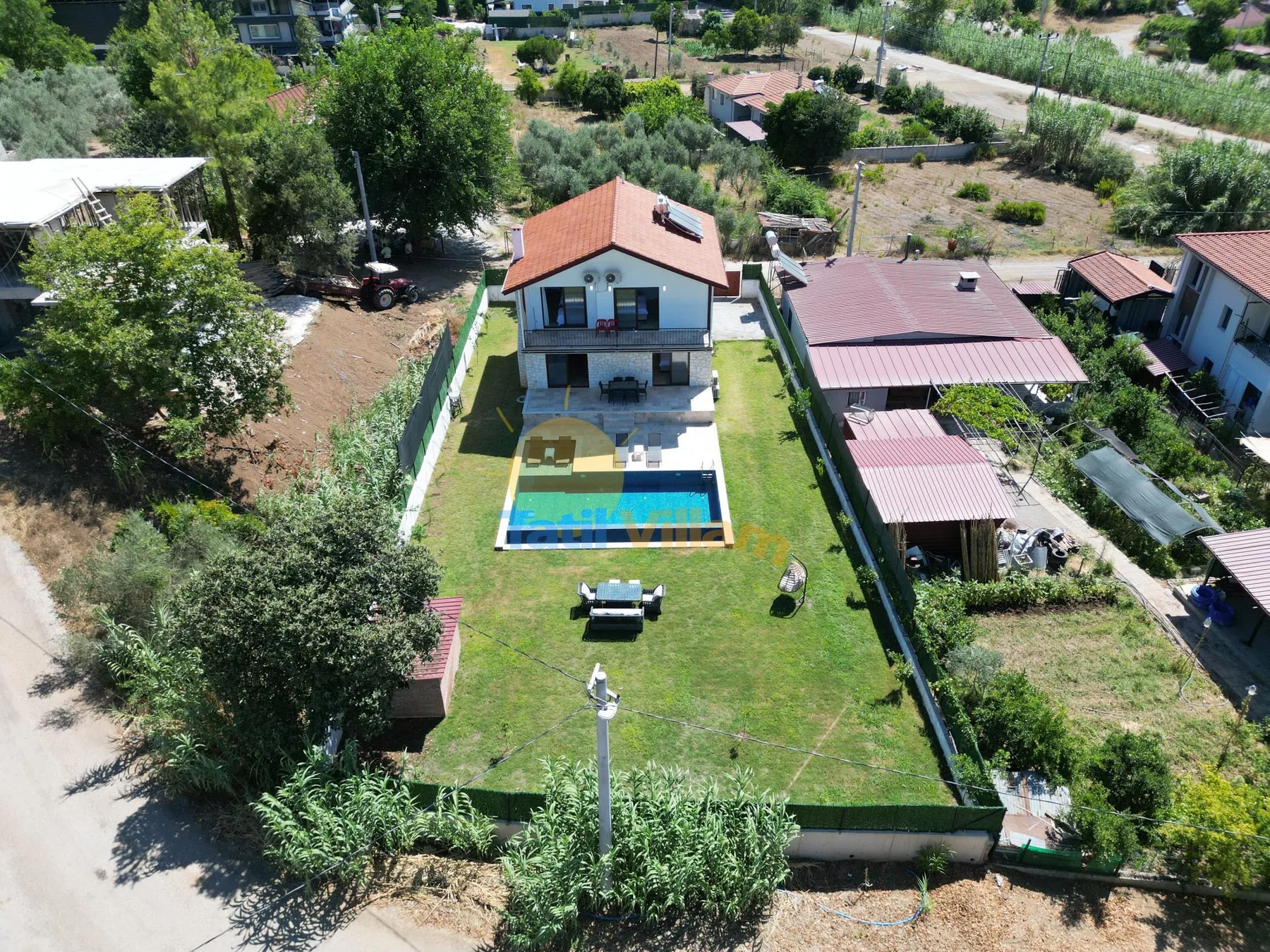 Vista aérea de una casa y un patio cercado con piscina.