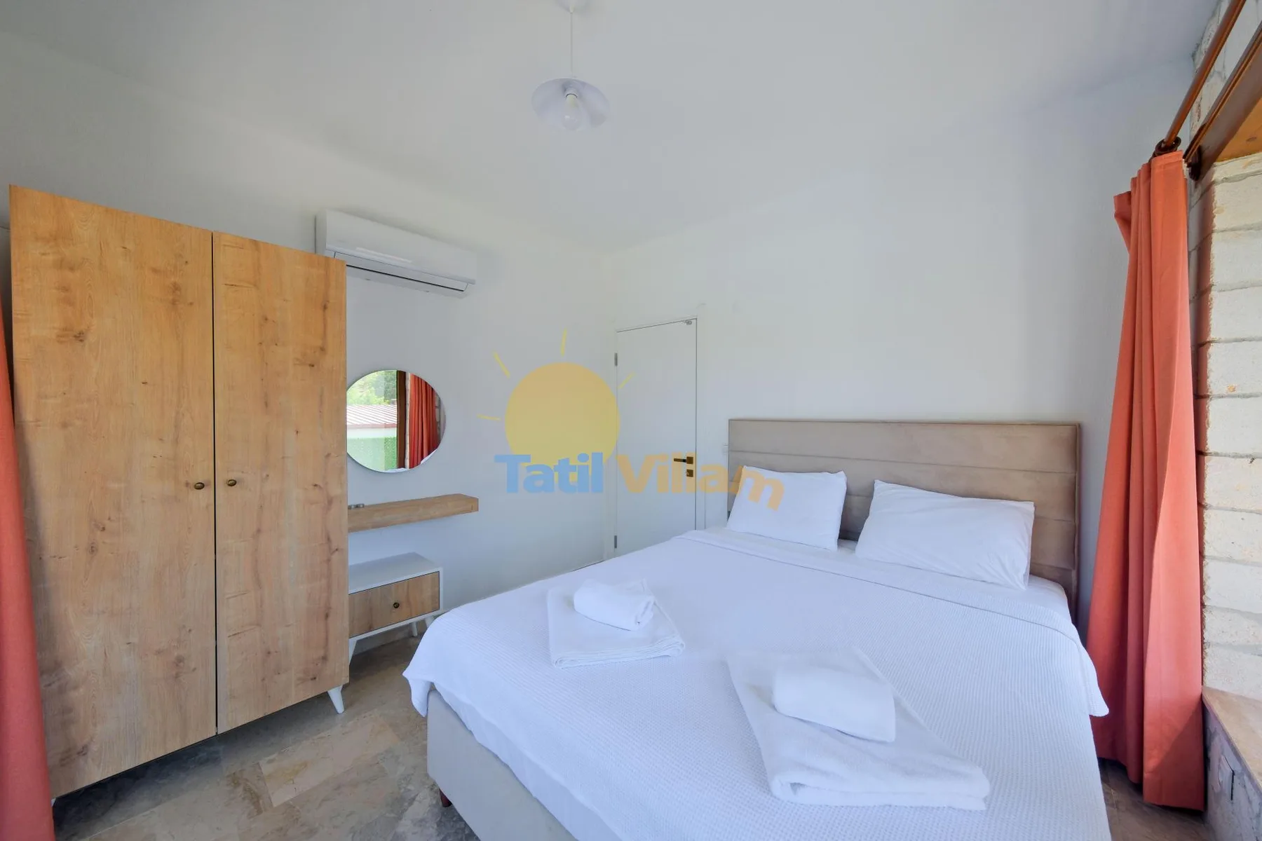 Un dormitorio con una cama tendida, un armario de madera y cortinas naranjas.