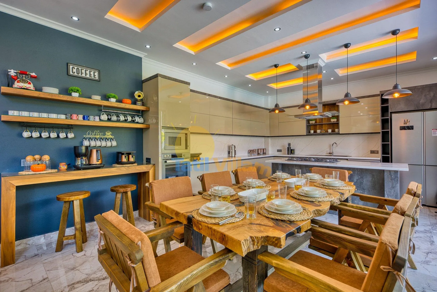 A dining area with wooden tables and chairs beside an open kitchen.