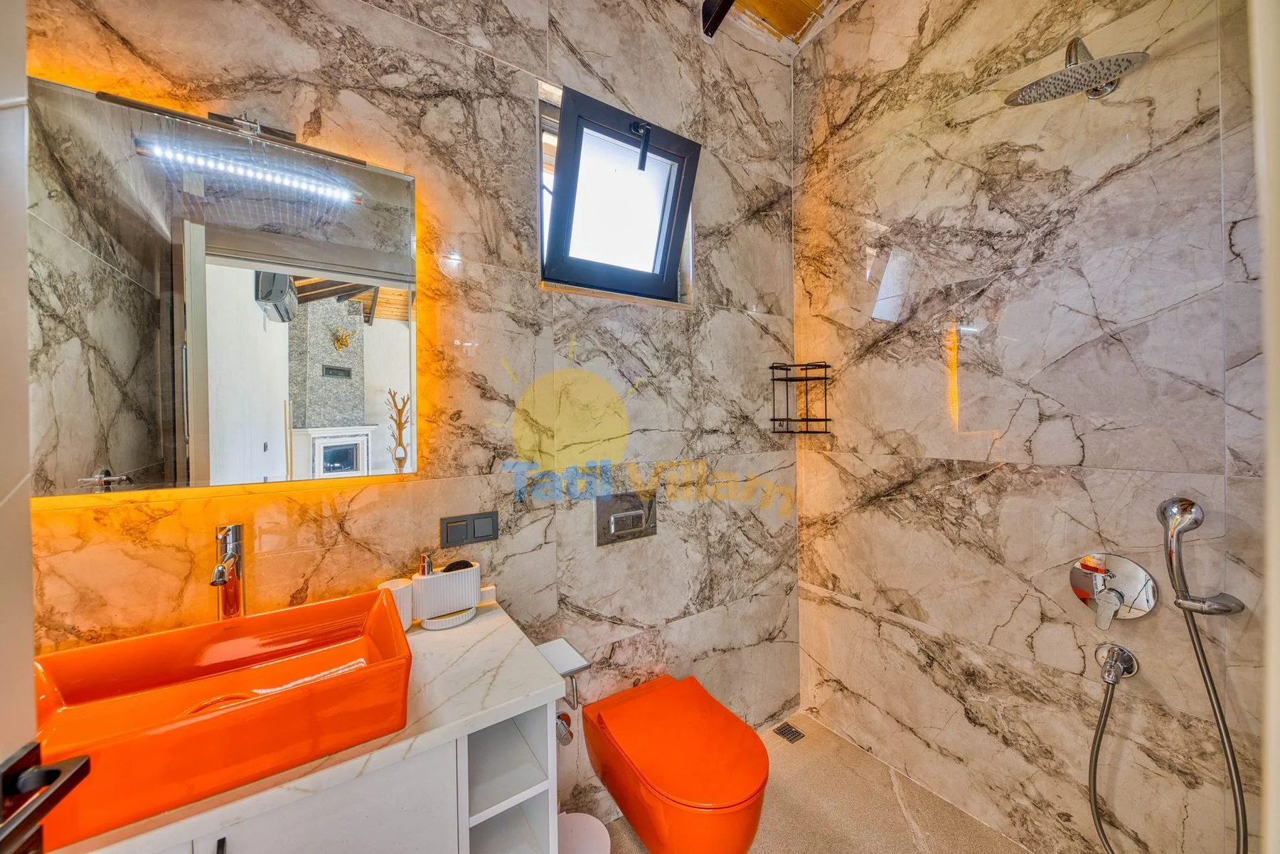 A marble-patterned bathroom with an orange sink and matching toilet.