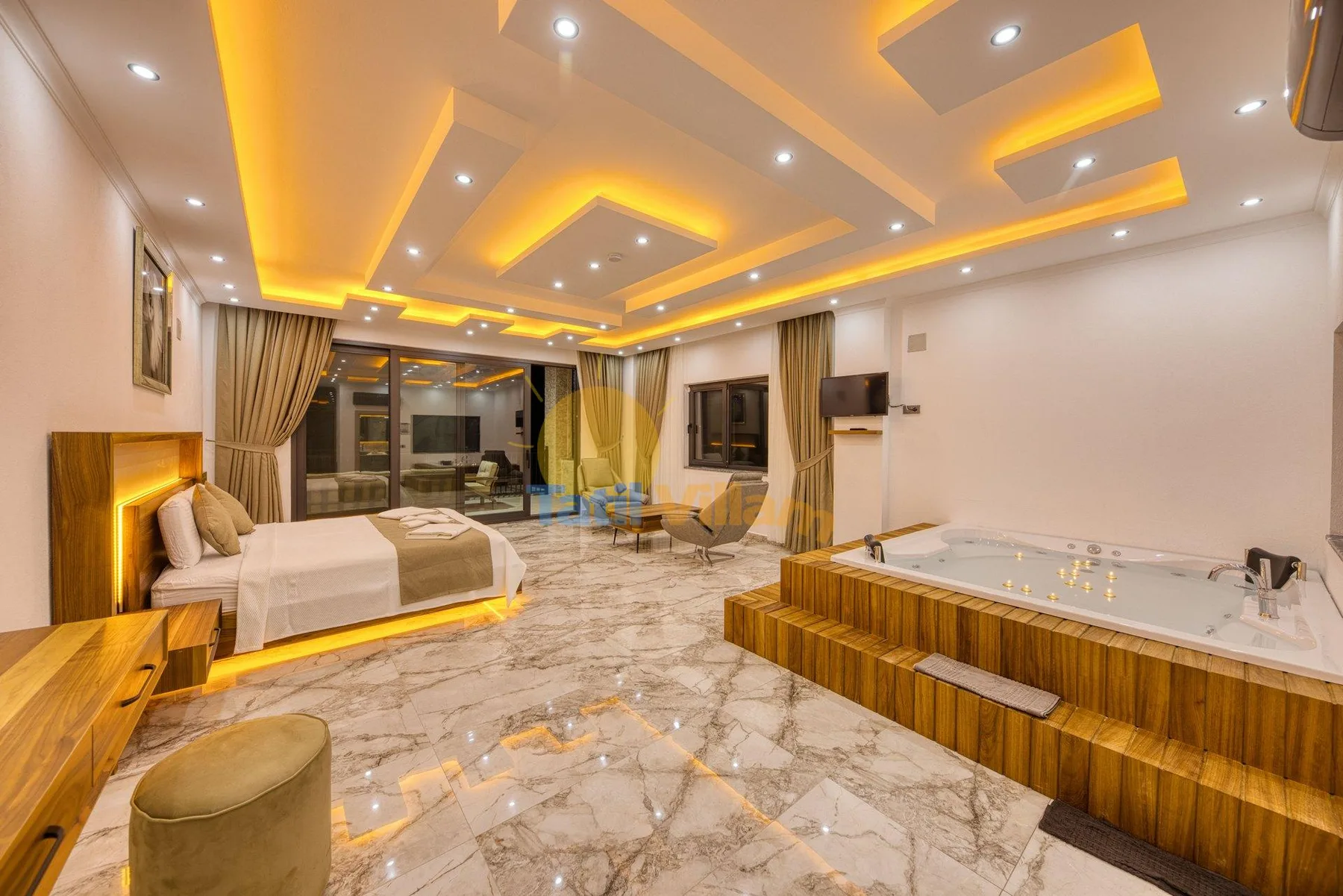 A bedroom with a bed, a bathtub, and warm recessed ceiling lights.