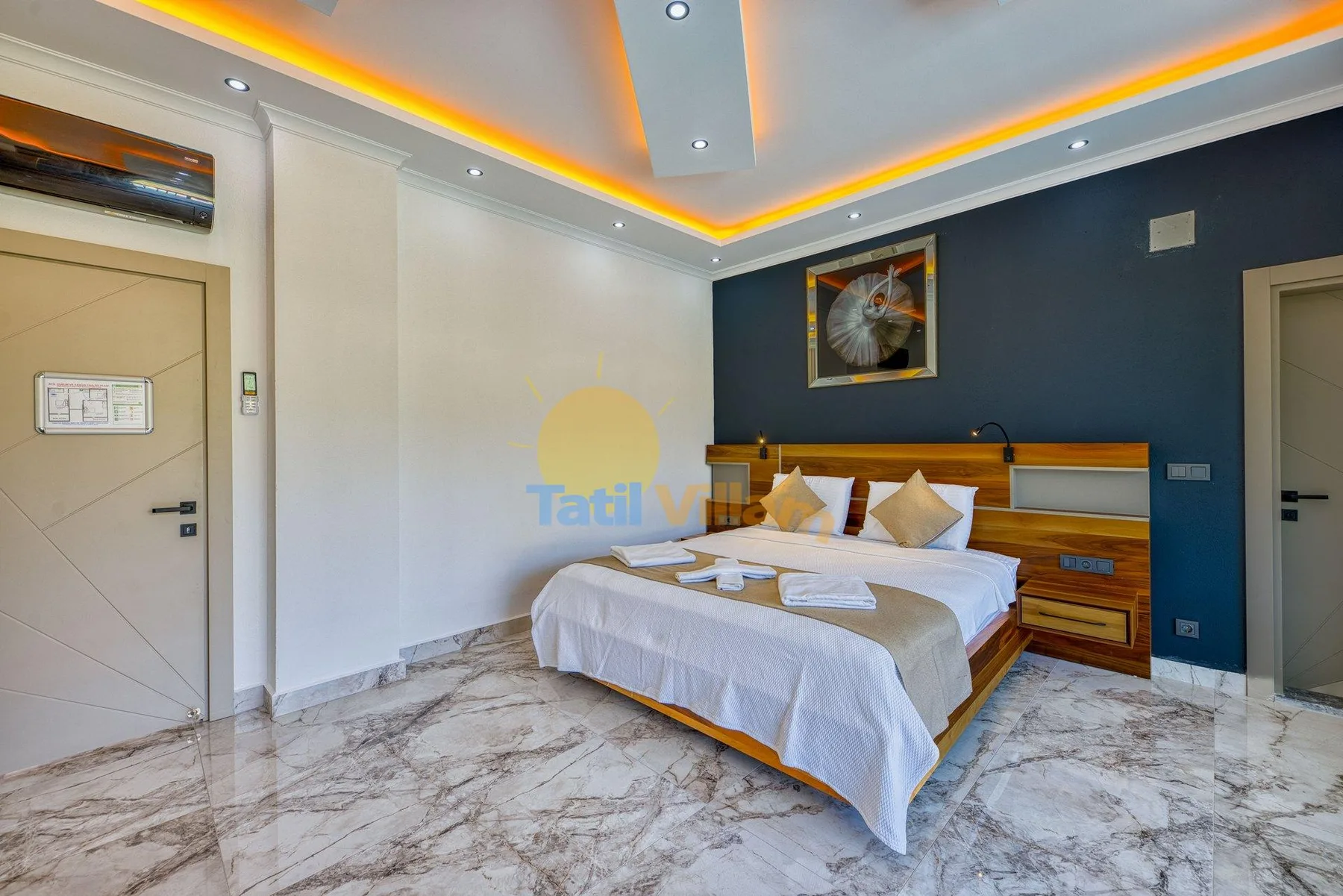 A bedroom with a bed, bedside tables, and a dark blue accent wall.
