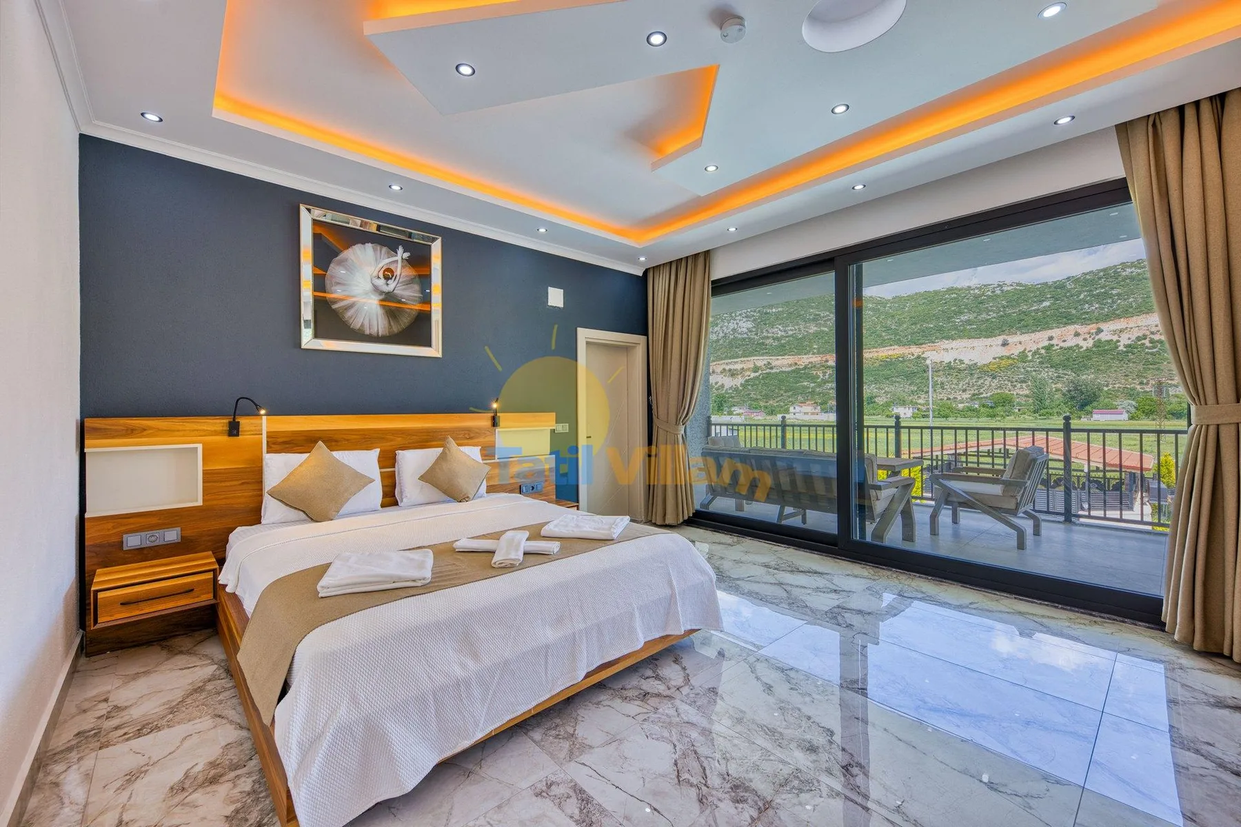 A bedroom with a large bed beside sliding glass doors opening onto a balcony.