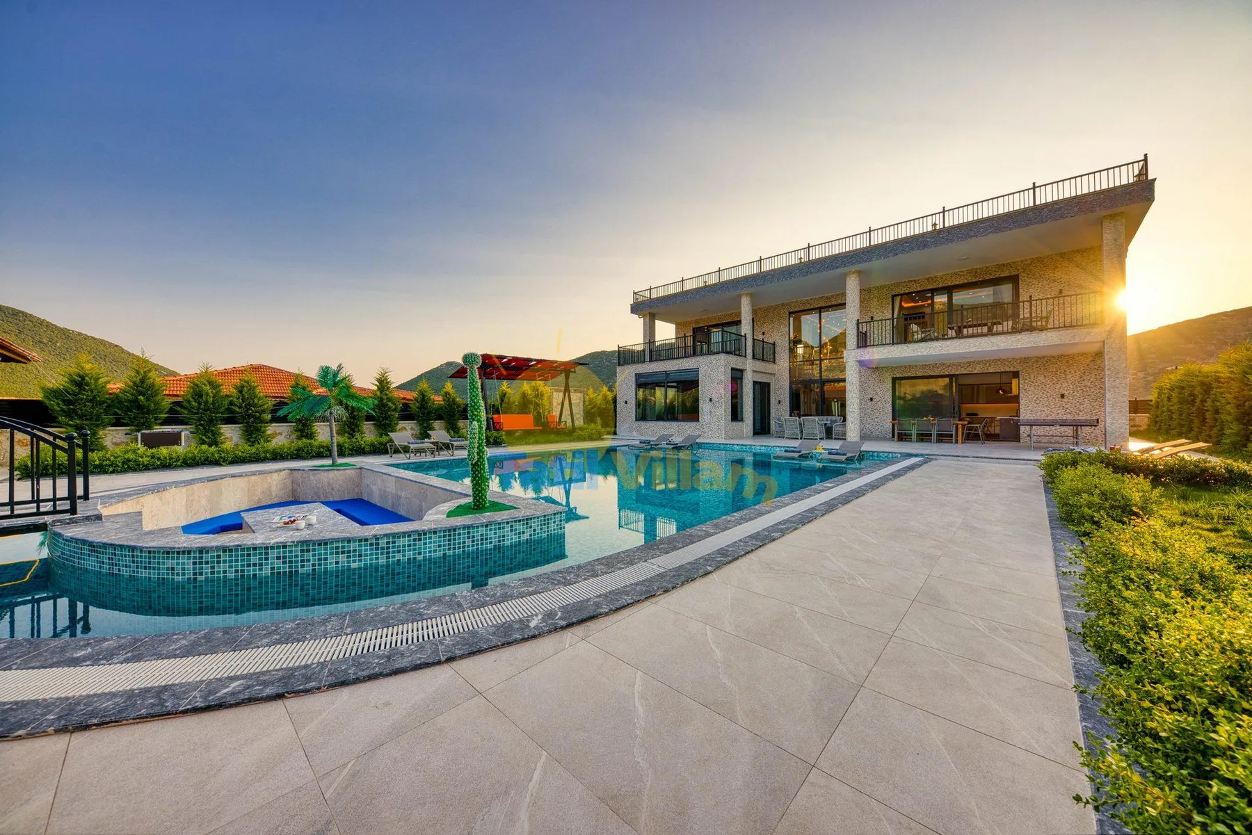 A modern house overlooks a swimming pool and tiled patio.