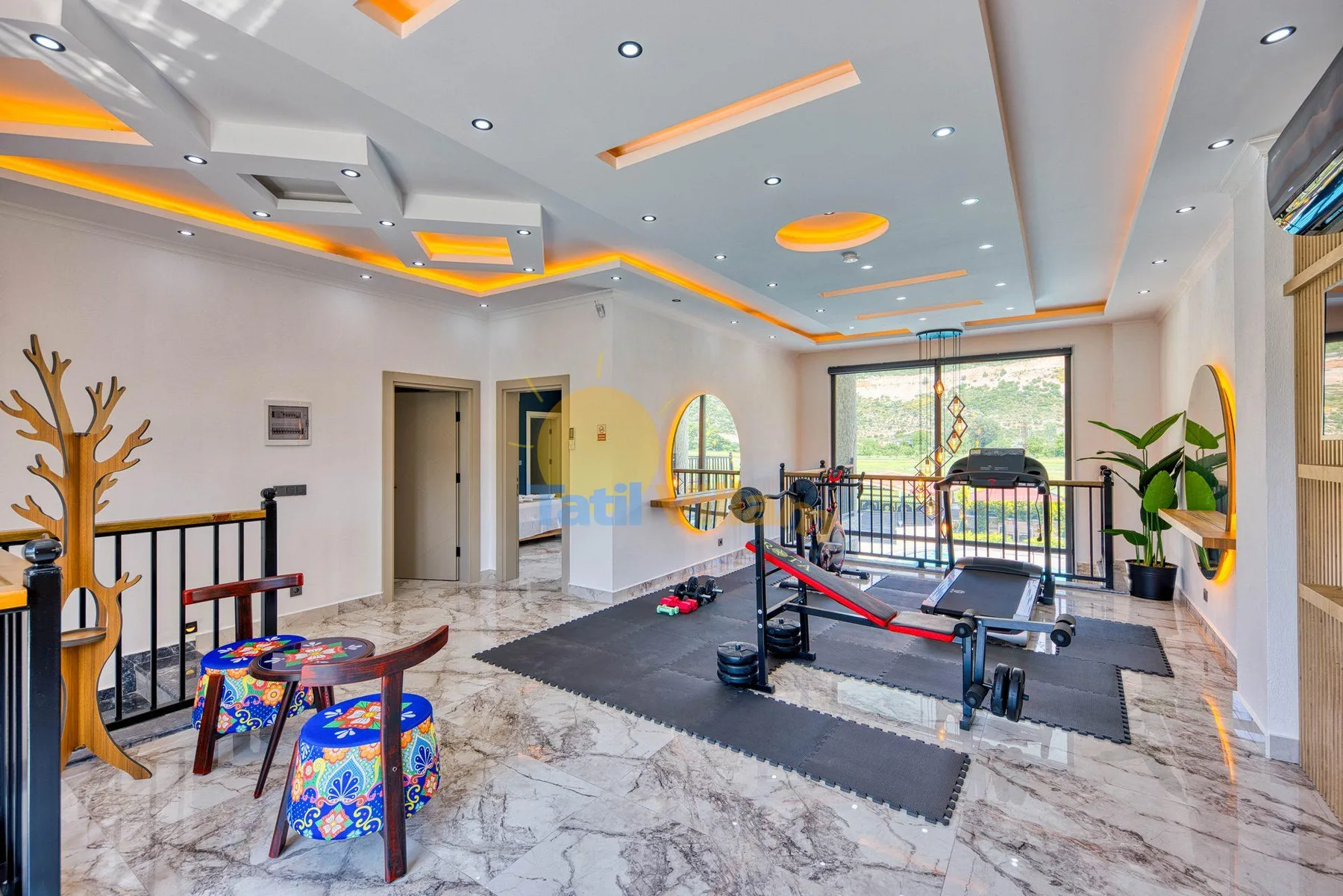 A bright indoor gym with exercise equipment and a large window.