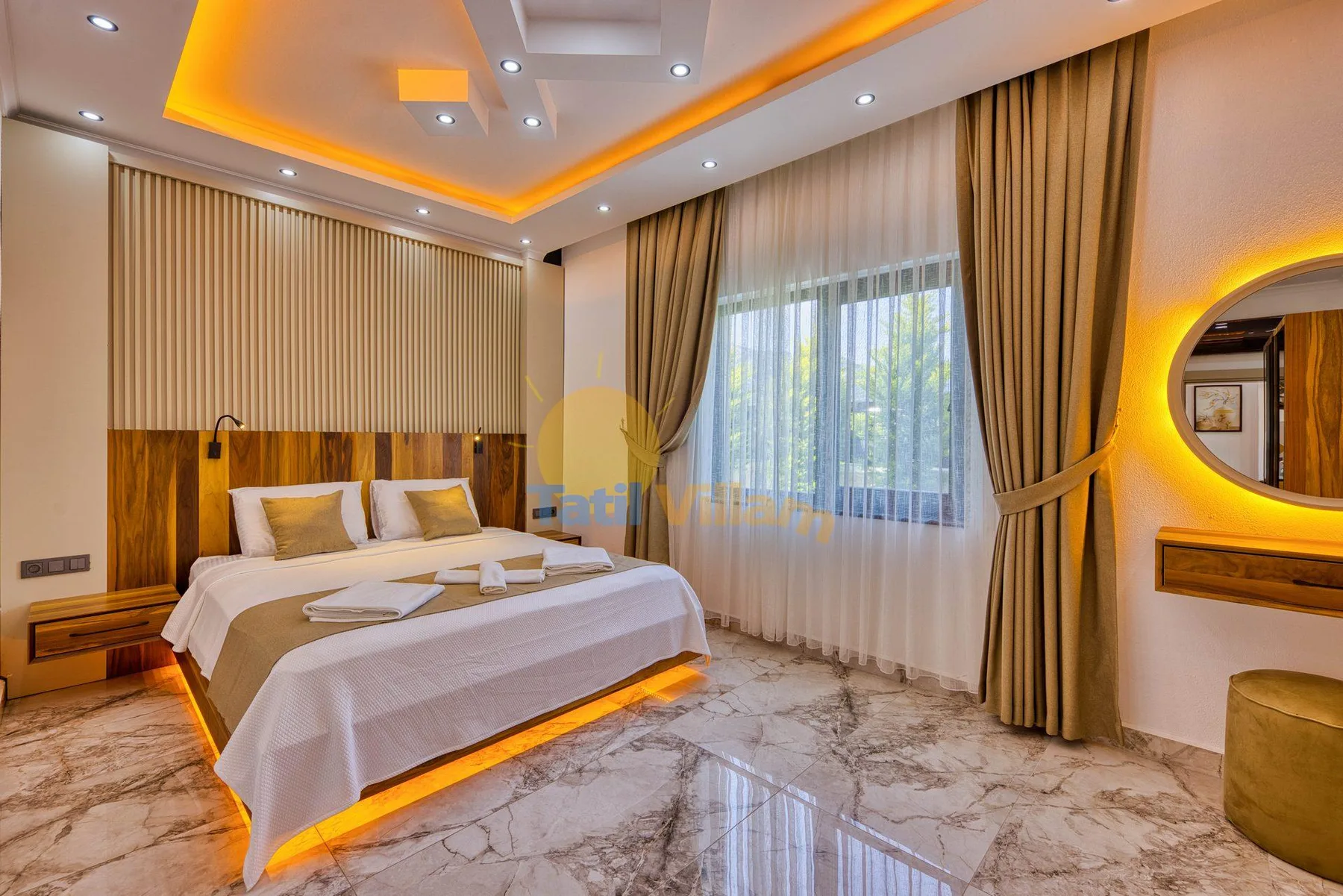 A bedroom with a bed beside a large curtained window.