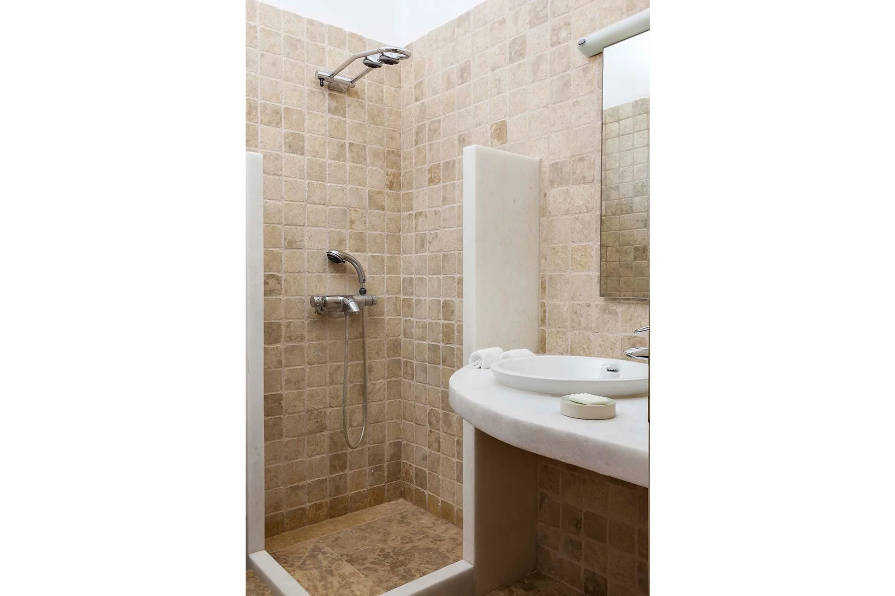 A tiled bathroom with a shower and sink.