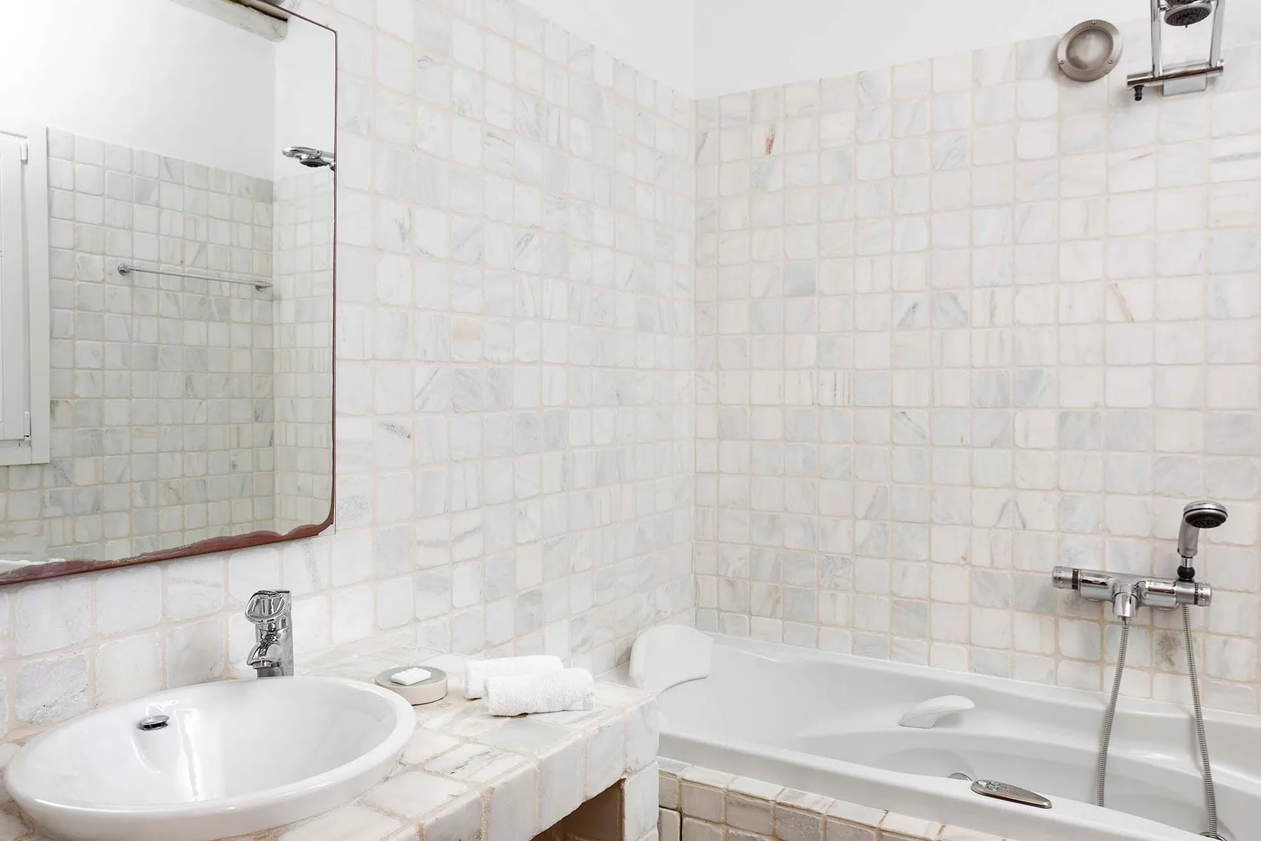 A tiled bathroom with a bathtub and sink.