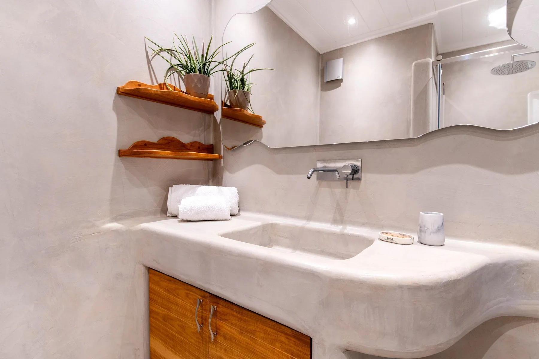 A bathroom with a wide sink and a large wall mirror.