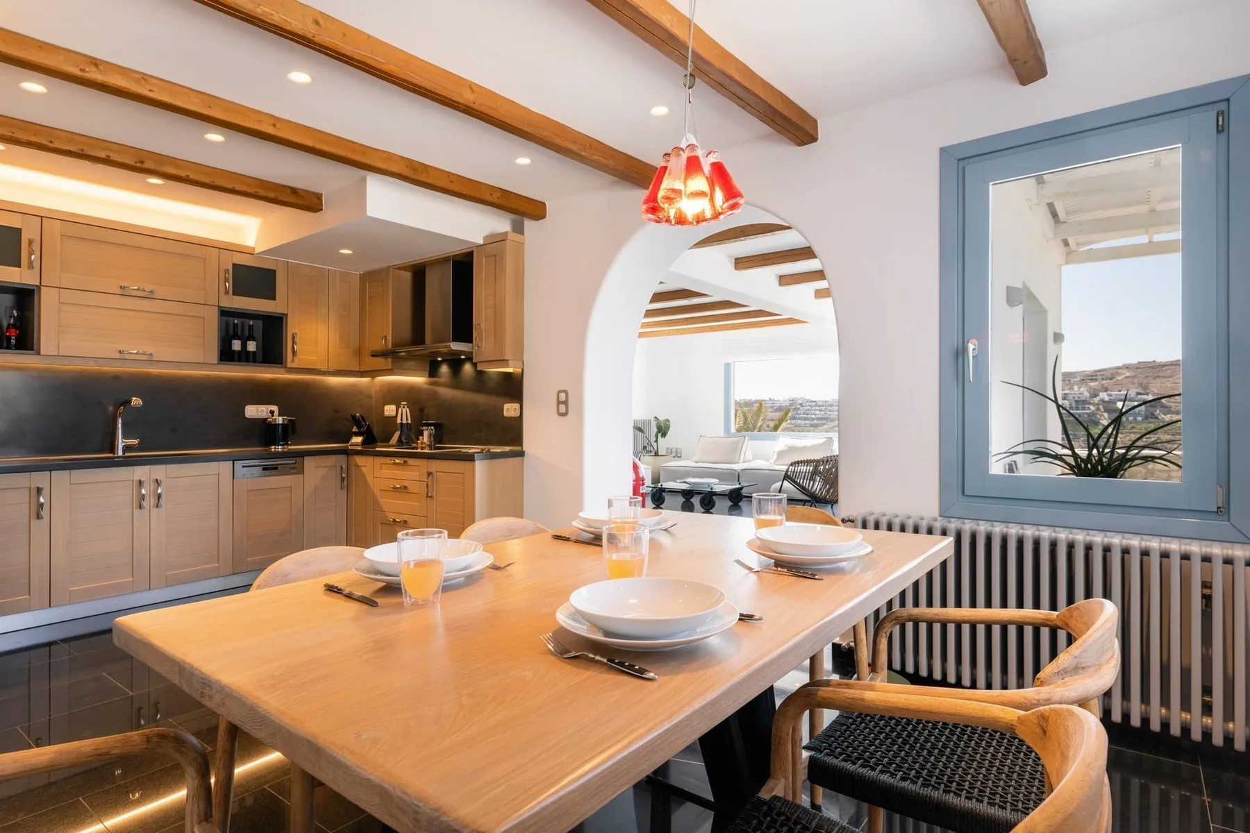 A dining area with a wooden table beside an open kitchen.