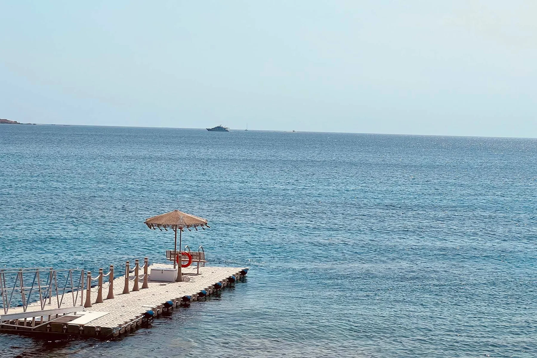 Shared amenity: A seaside pier extends over clear blue water beneath a shaded canopy.
