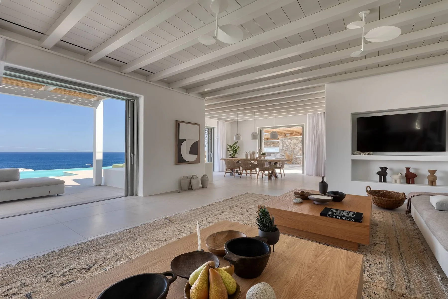 A bright living room opens onto a terrace with ocean views.