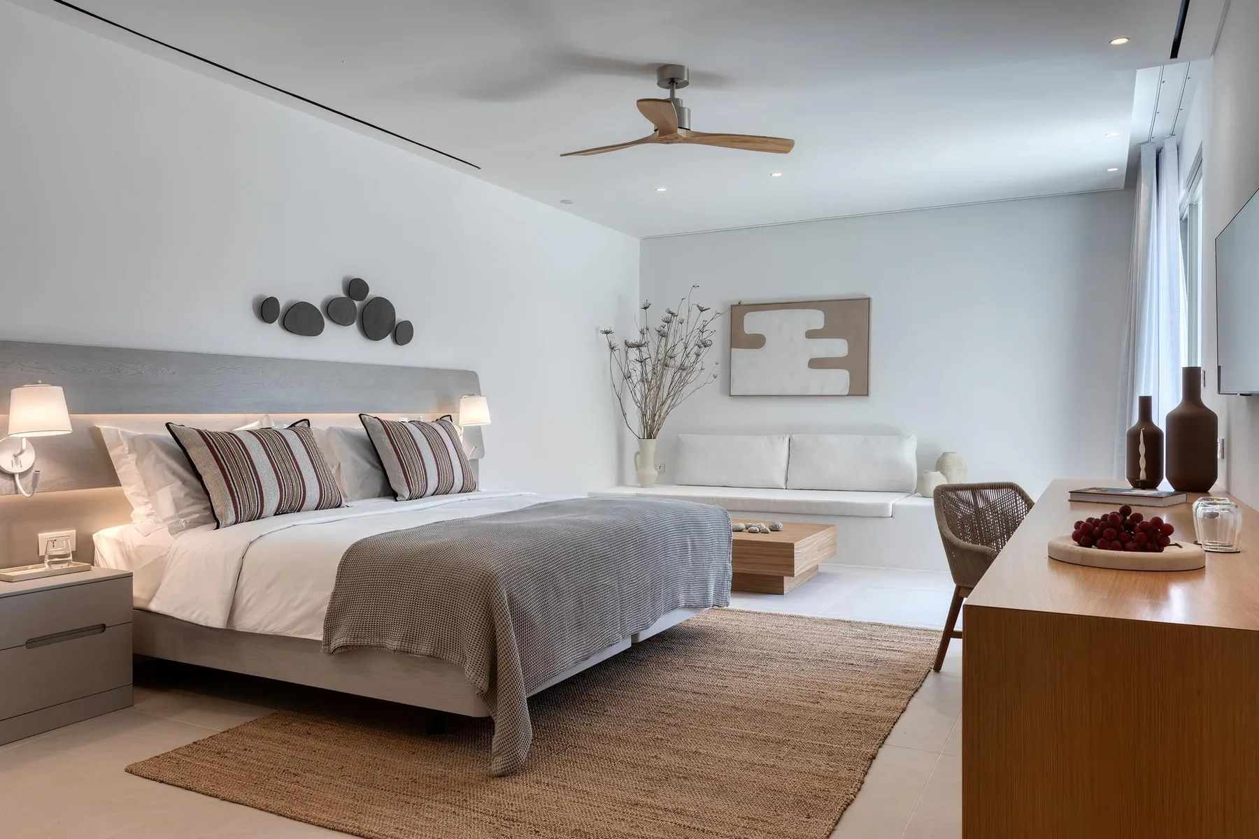 A bright bedroom with a large bed and a sitting area by the window.