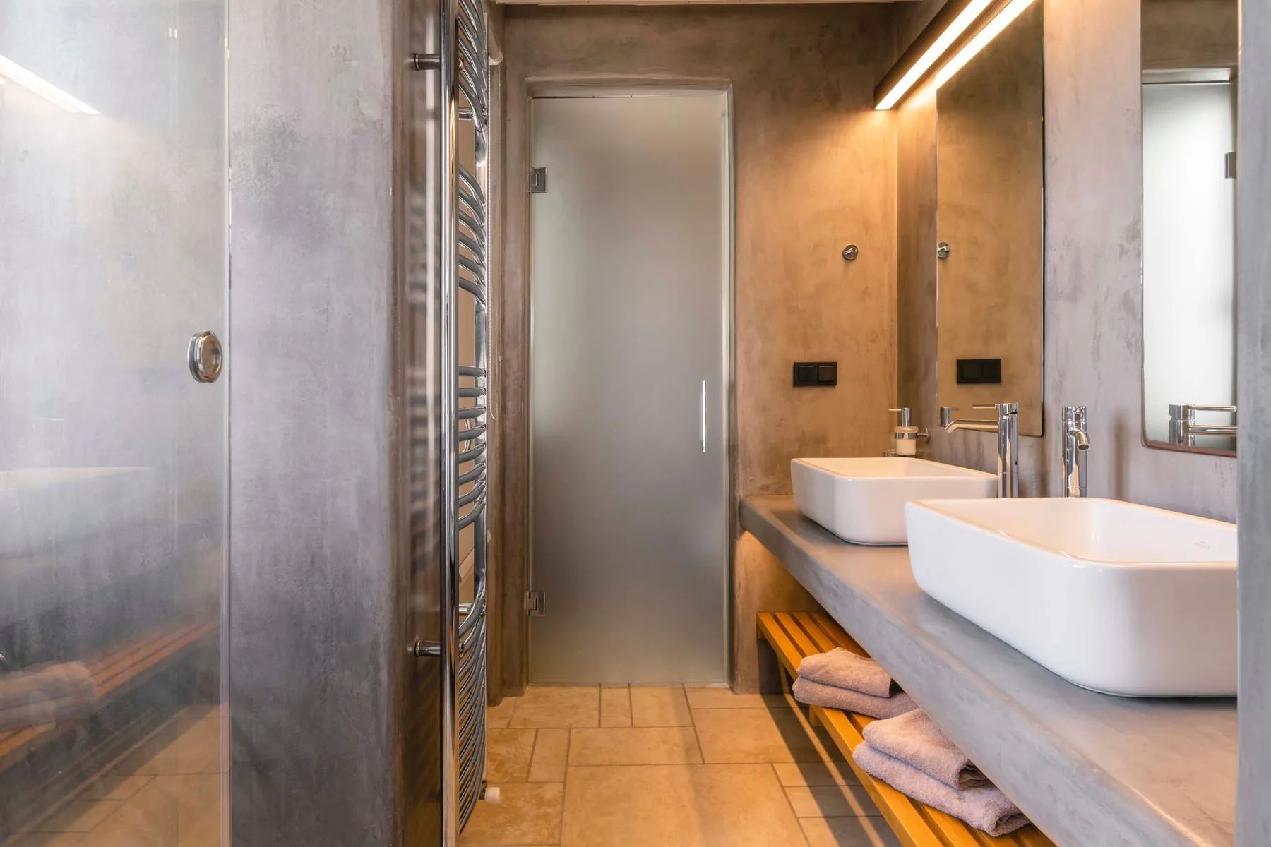 A modern bathroom with a long vanity and two white vessel sinks.