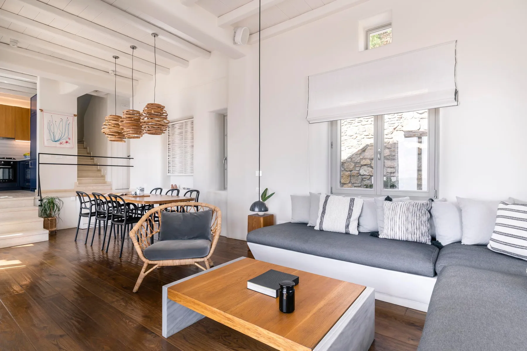 An open-plan living and dining area with a long table and sectional seating.