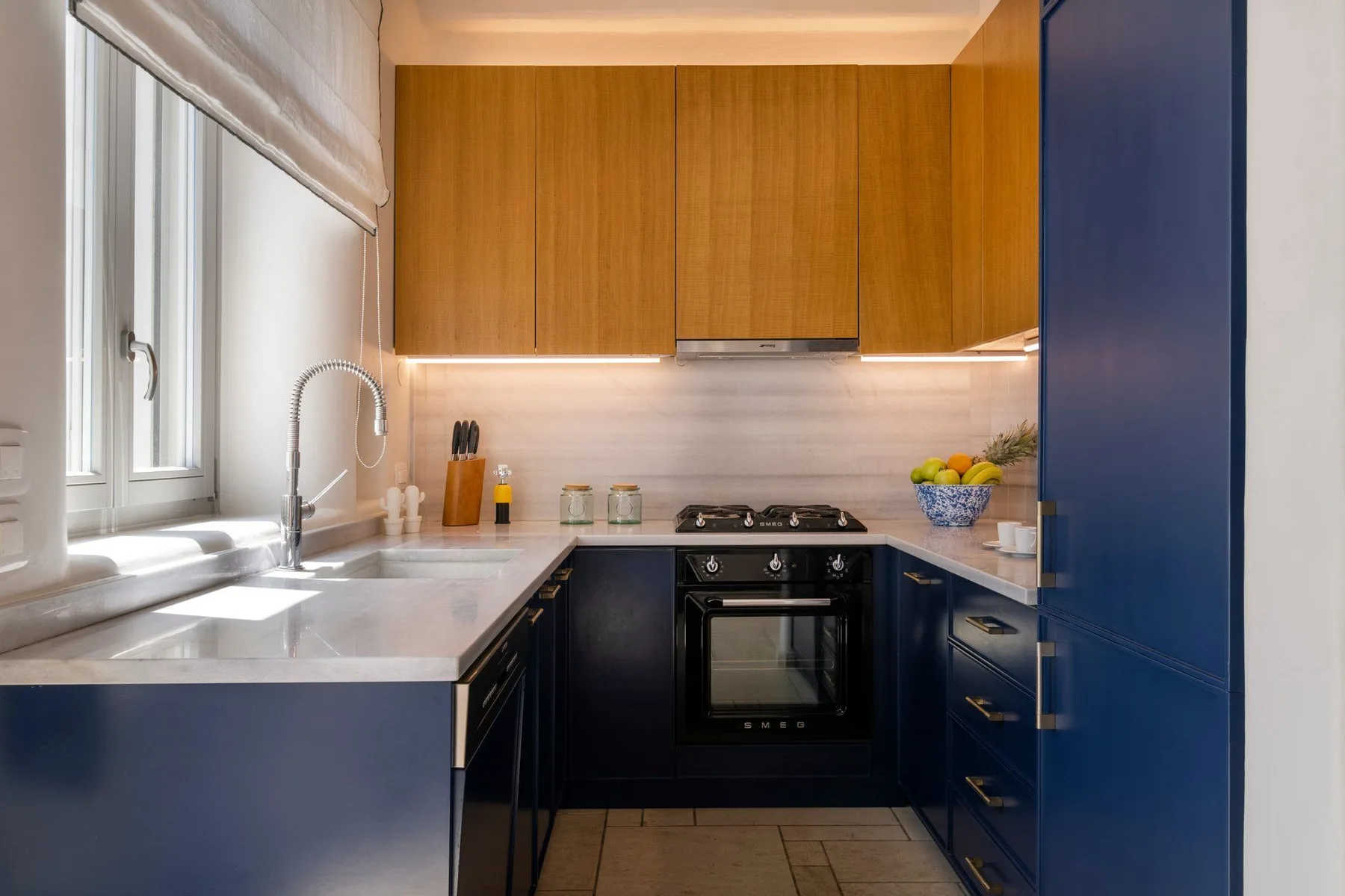 A modern kitchen with dark cabinets, wood-toned upper cabinets, and a countertop.