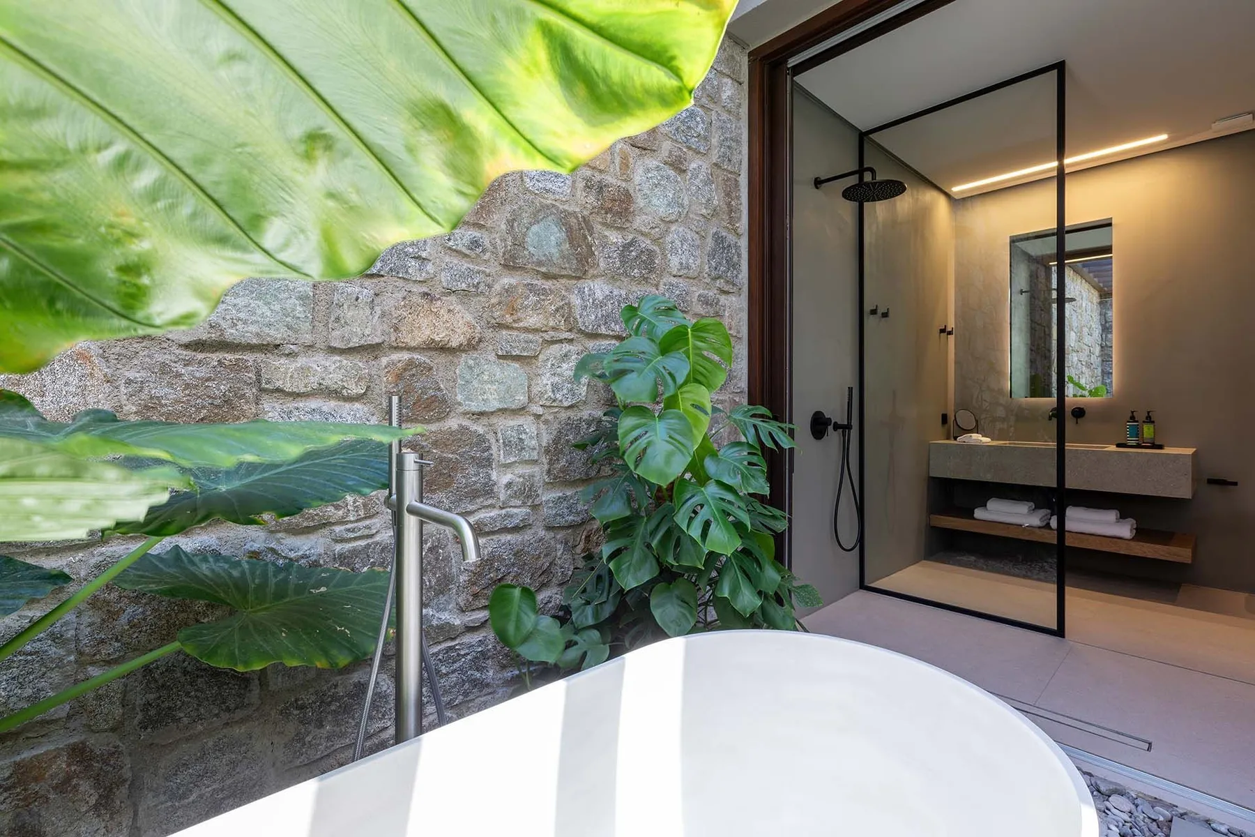 A bathroom with a freestanding bathtub beside a glass-enclosed shower.