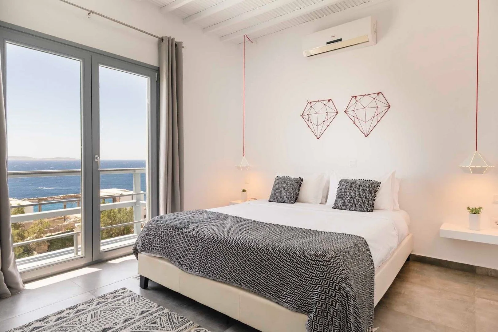A bedroom with a double bed and glass doors opening onto a balcony.