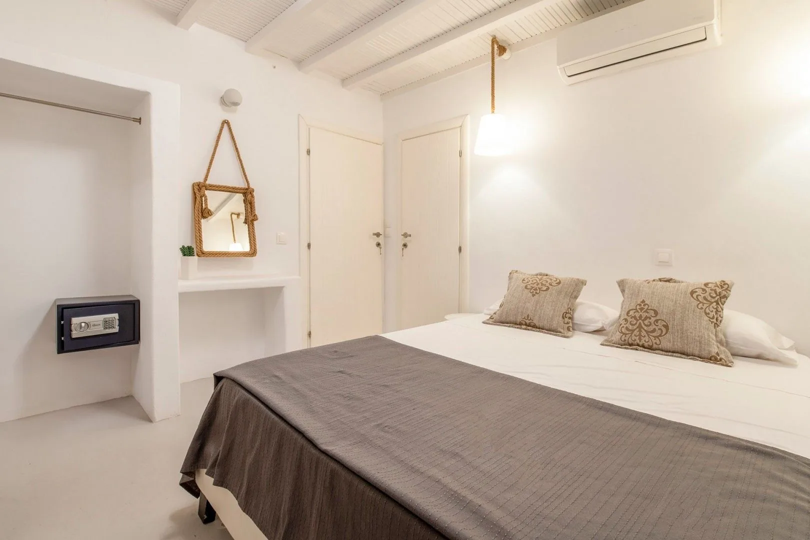 A bright bedroom with a large bed and neutral bedding.