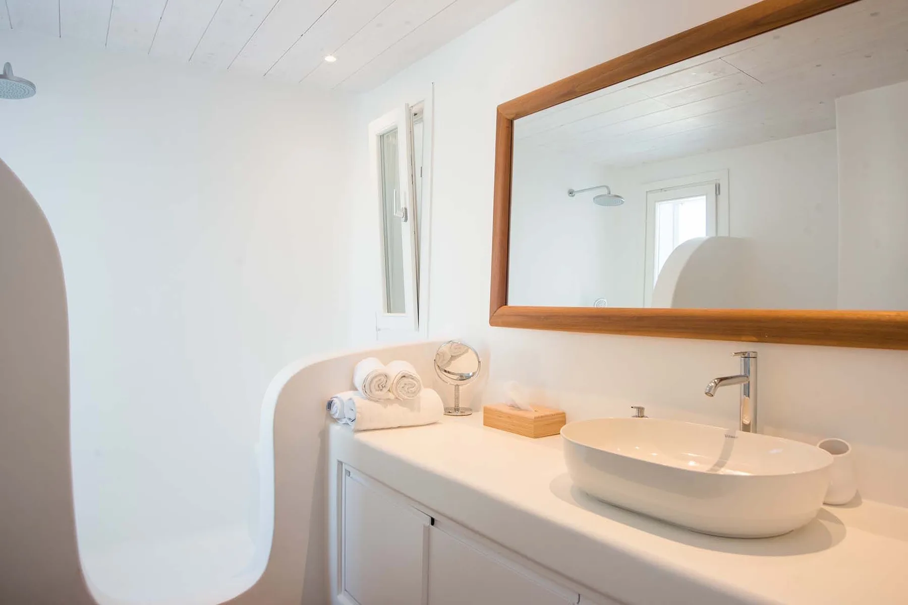 A bright bathroom vanity with a basin and a large wall mirror.